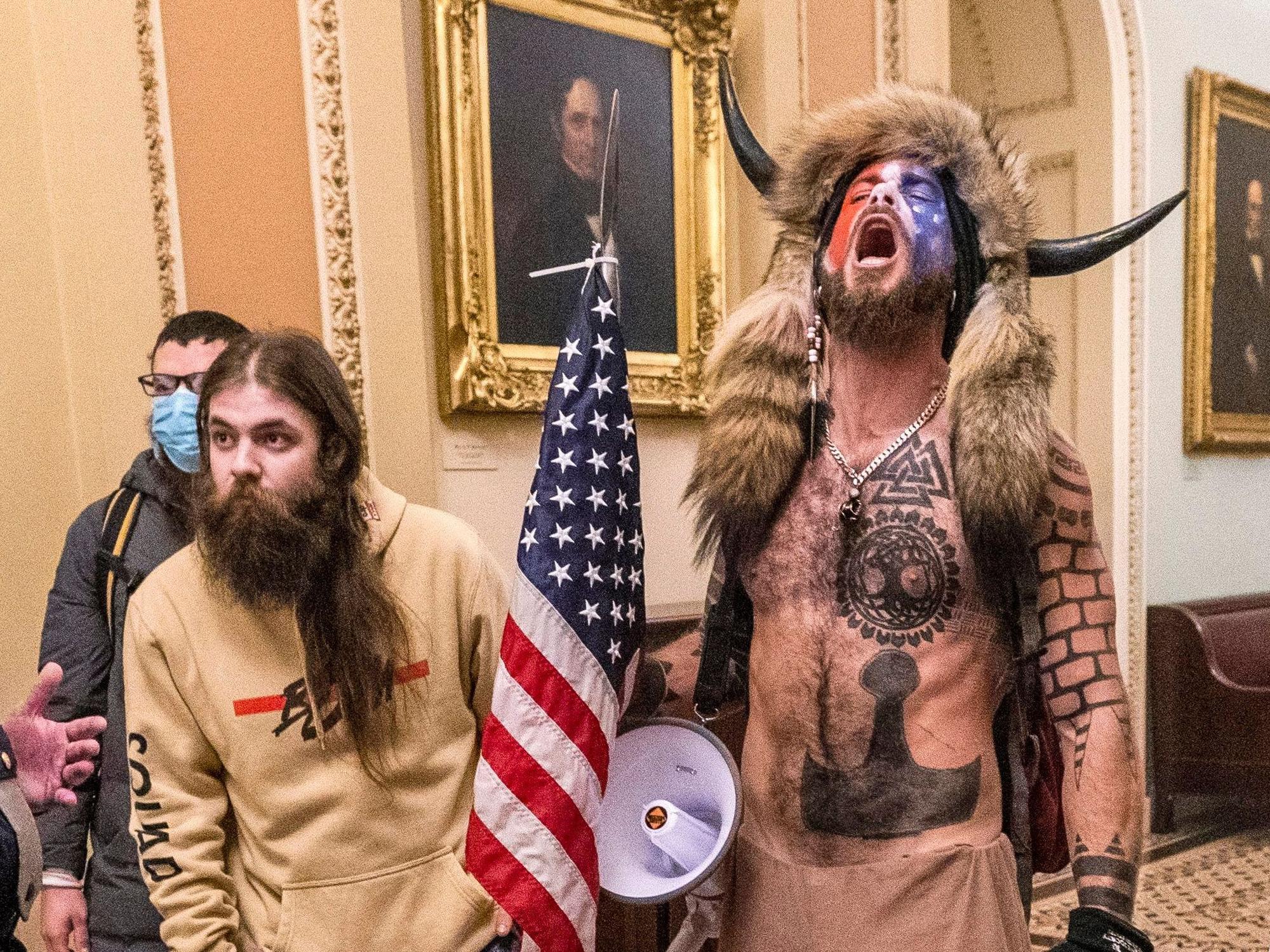 Bilder, die um die Welt gingen: Trump-Anhänger stürmen am 6. Januar das Kapitol in Washington. Jacob Anthony Chansley, der „QAnon-Schamane“ mit der Büffelhorn-Mütze (rechts), war ein Gesicht des Sturms. Er wurde nun verurteilt.