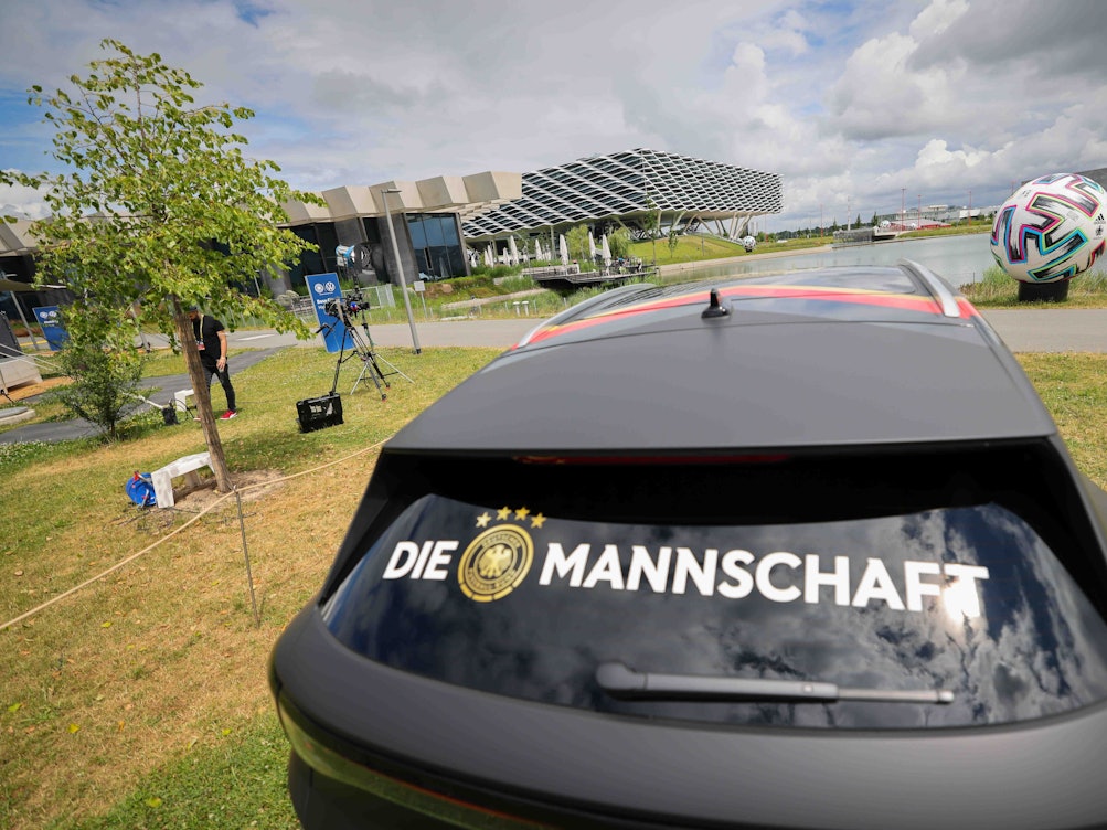 Der Schriftzug „Die Mannschaft“ klebt auf der Heckscheibe eines Volkswagen ID.4 im Bereich des DFB-Medienzentrums auf dem Gelände von Adidas.