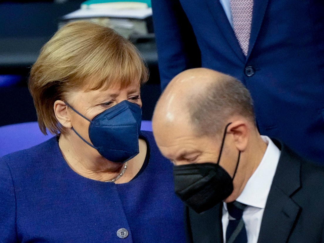 Angela Merkel spricht mit Olaf Scholz im Bundestag.