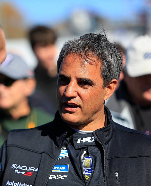 Juan Pablo Montoya spricht mit einem Teammitglied.
