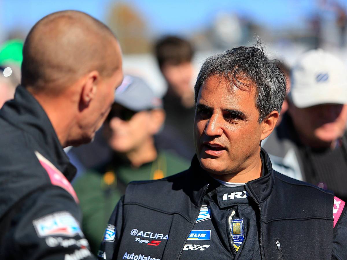 Juan Pablo Montoya spricht mit einem Teammitglied.