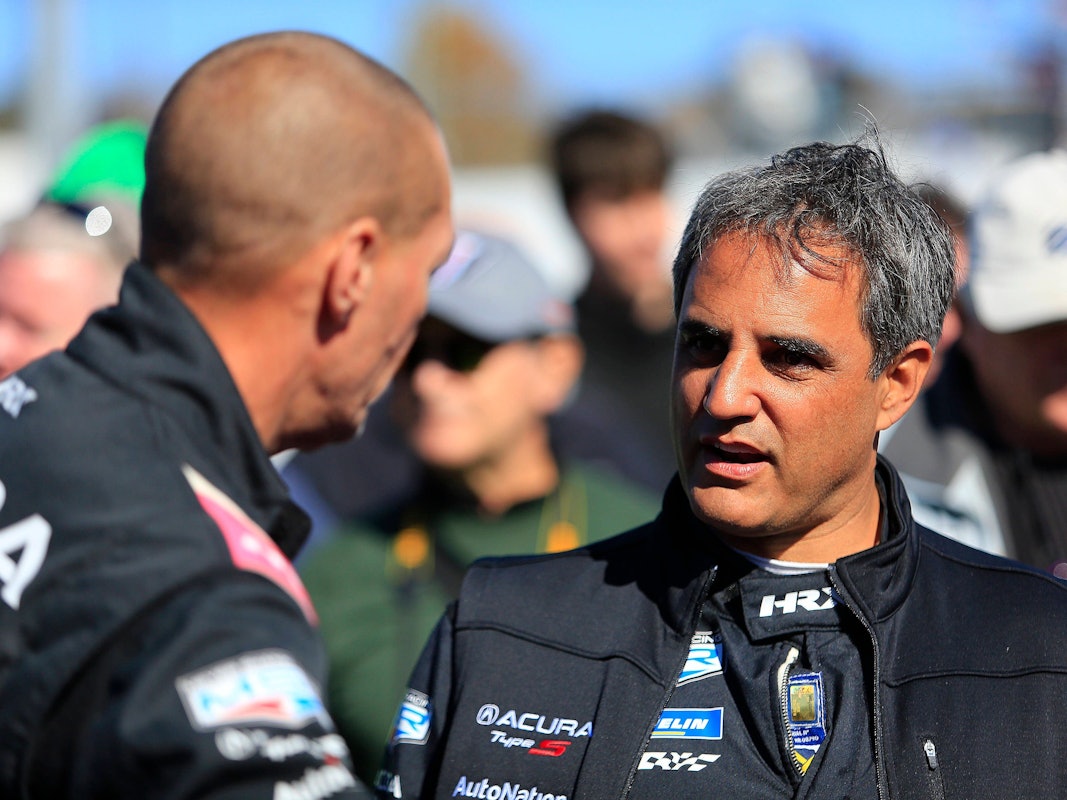 Juan Pablo Montoya spricht mit einem Teammitglied.