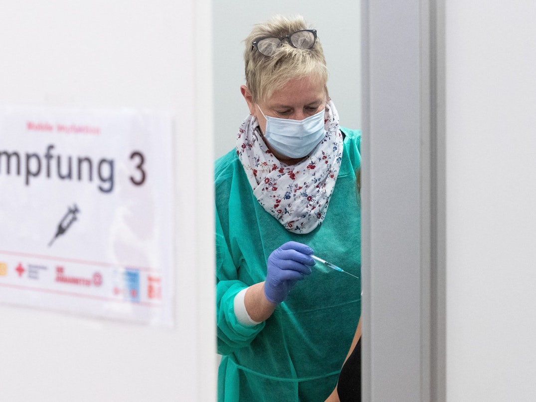 Arzthelferin Beate Bug hält eine Spritze bereit zur Impfung in einem Impfzelt.