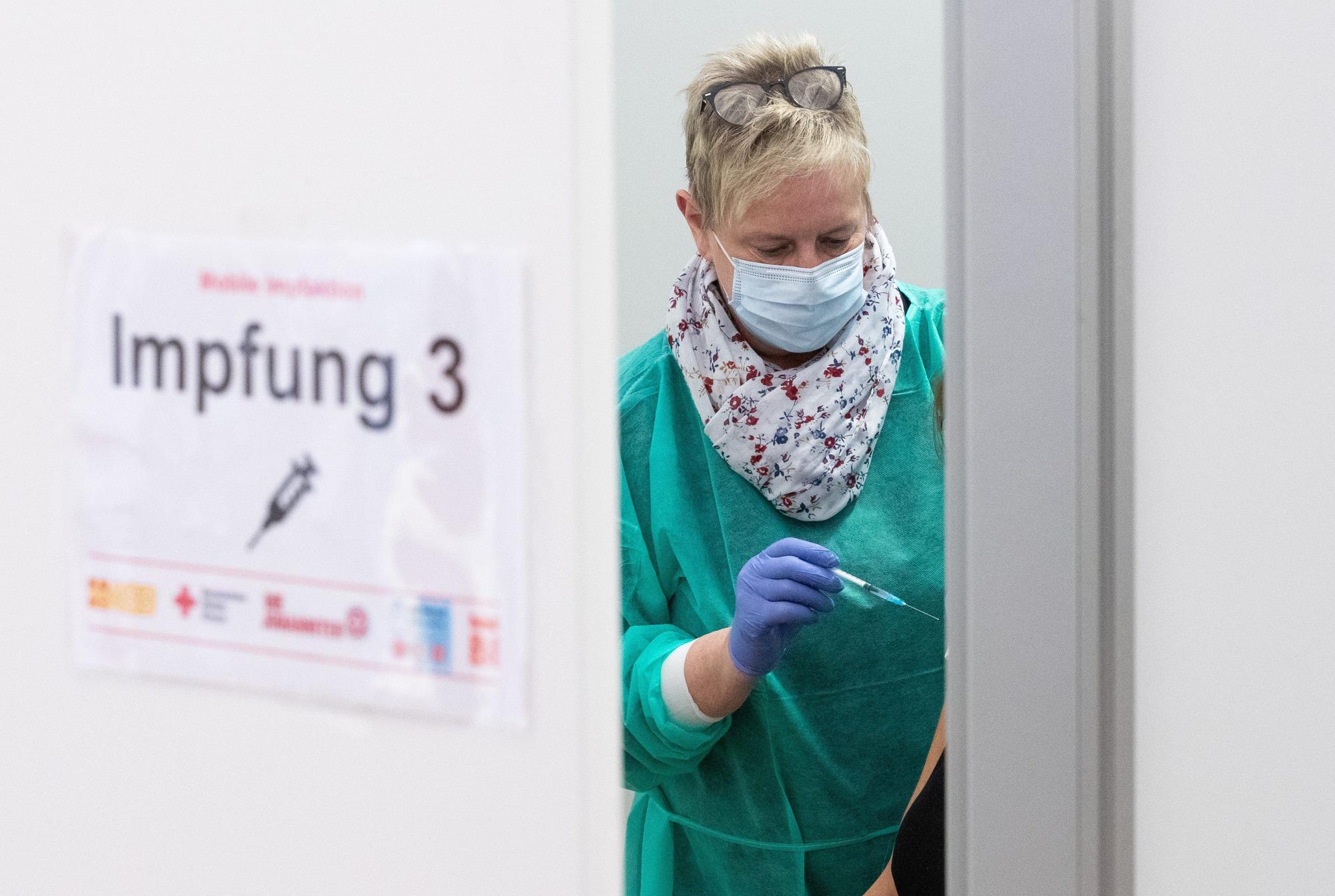 Arzthelferin Beate Bug hält eine Spritze bereit zur Impfung in einem Impfzelt.