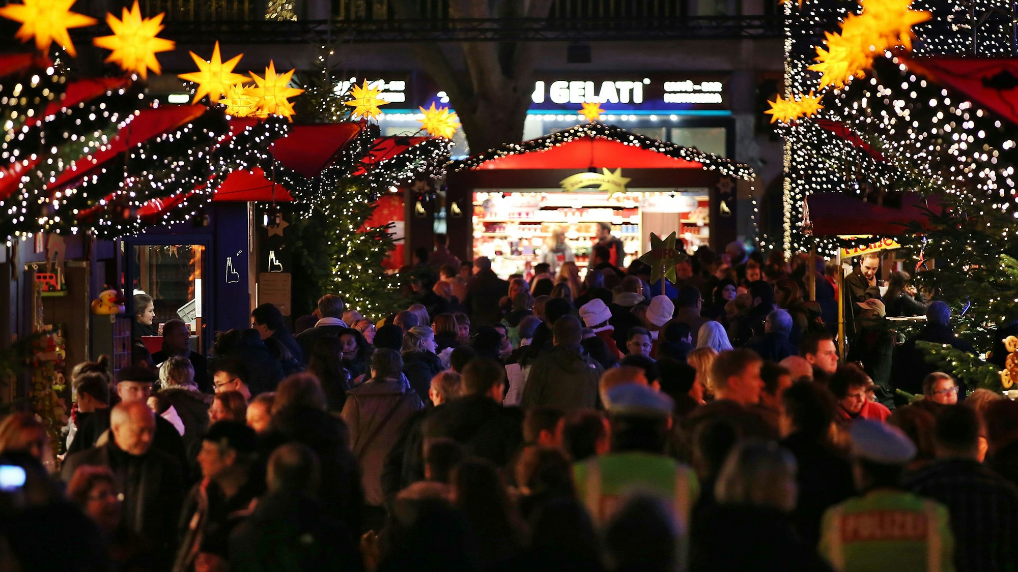 Menschen gehen über den Weihnachtsmarkt am Dom.