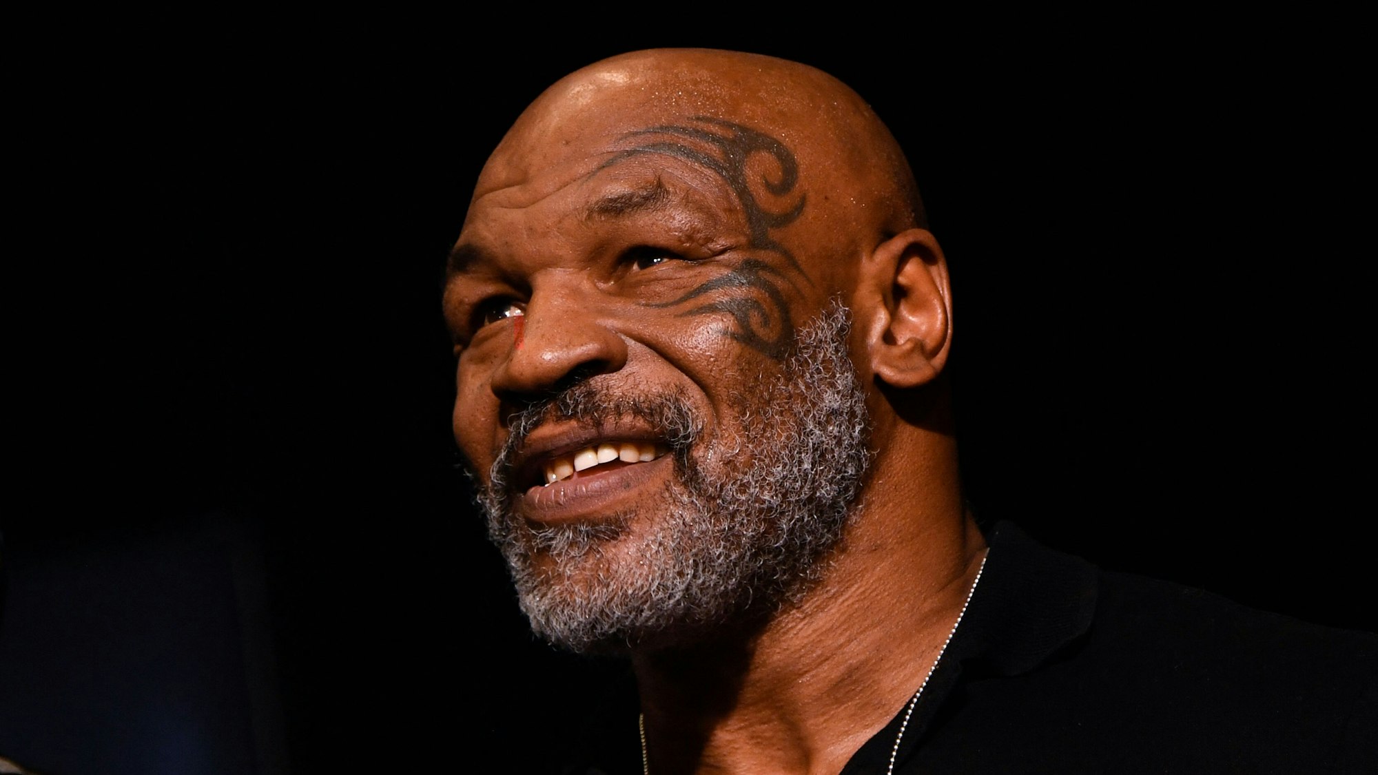 Mike Tyson sitzt bei einem Boxkampf auf der Tribüne