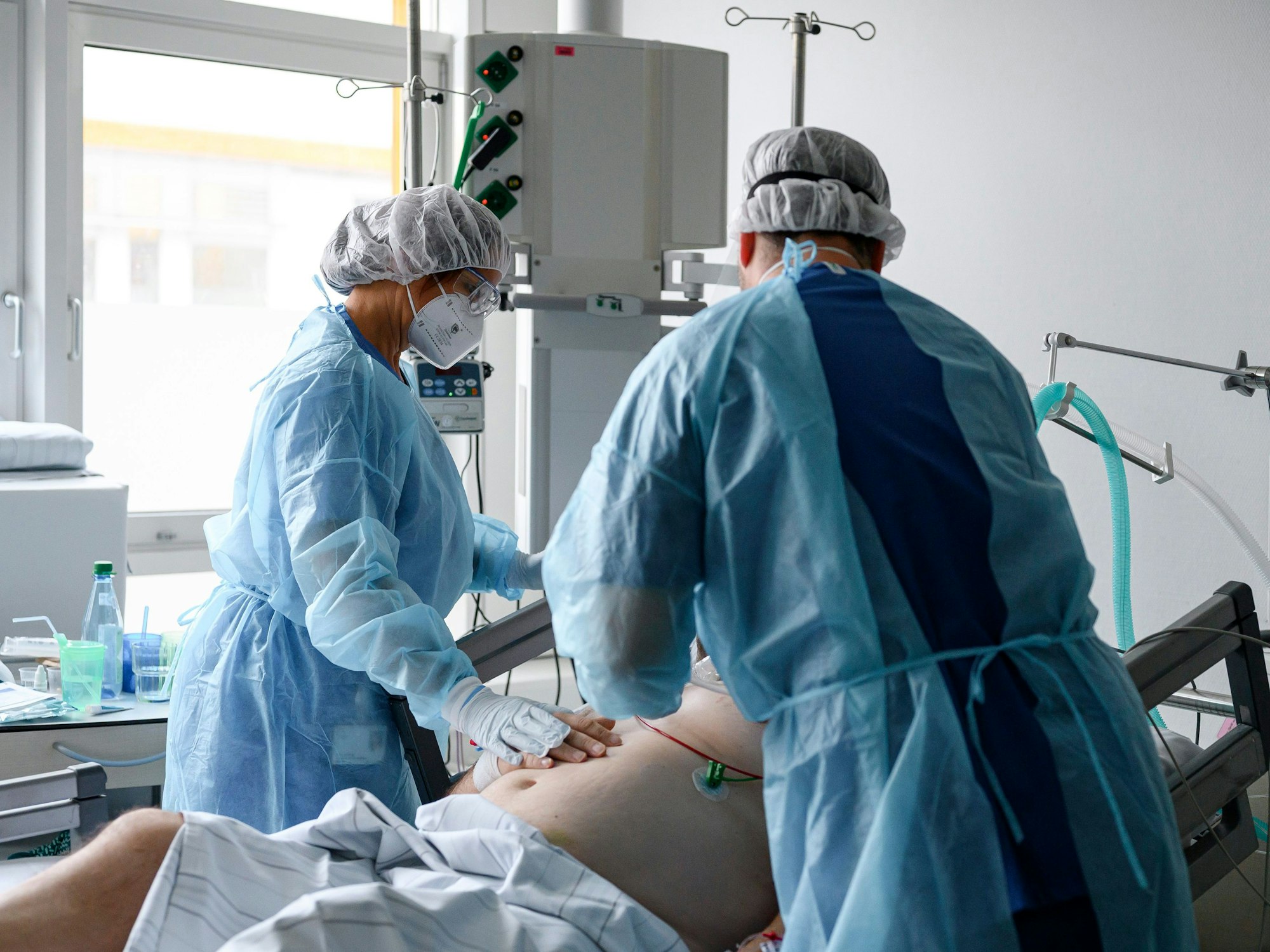 Bayern, Fürth: Die pflegerische Leitung der Intensivstation, Petra Stellwag (l), und Intensivstationsarzt Ullrich Voran (r) bei einem Corona-Patienten auf der Intensivstation.