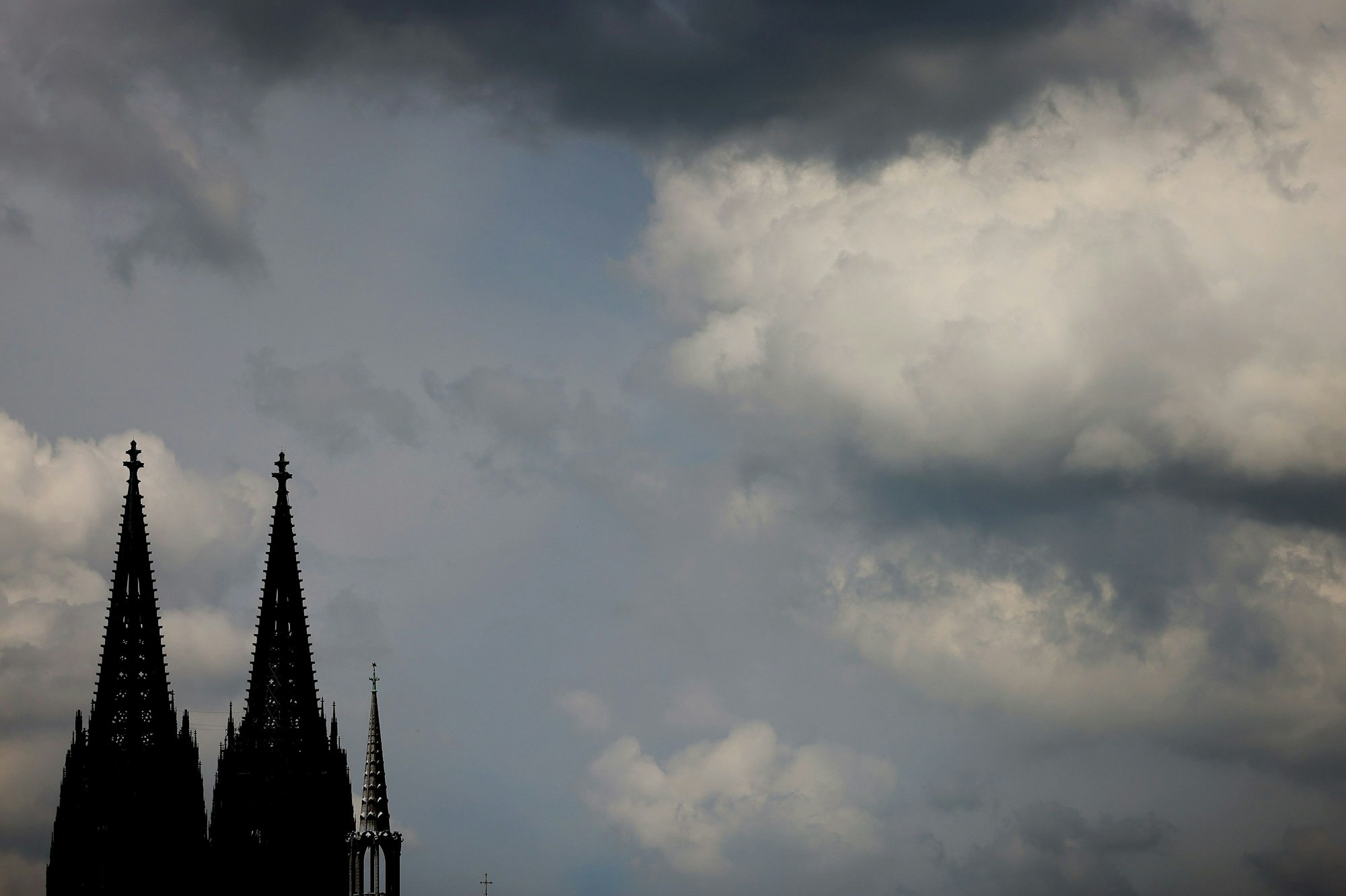 Die Spitzen des Kölner Doms vor Wolkenhimmel.