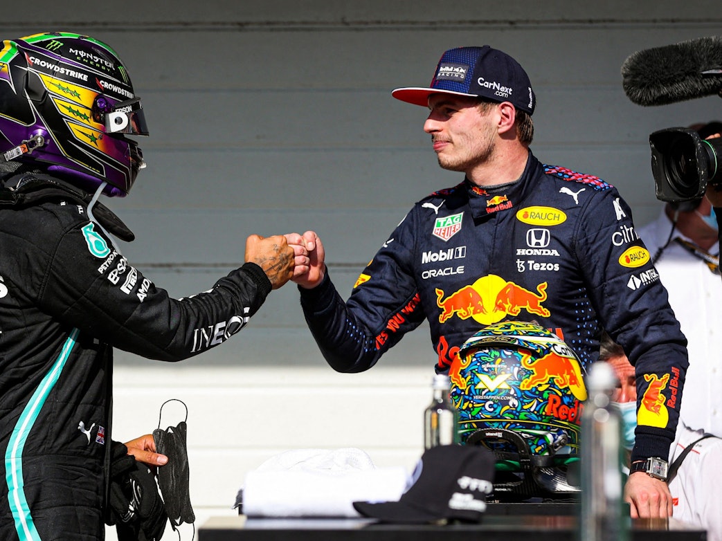 Lewis Hamilton und Max Verstappen klatschen miteinander nach dem Rennen der Formel 1 in Brasilien ab.