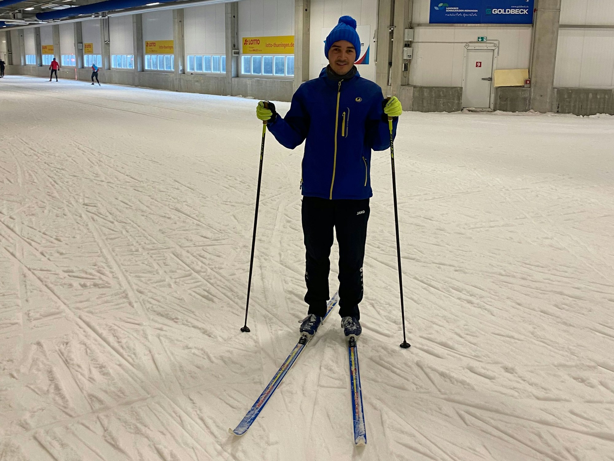 Der Kölner Student Amadeo Kaus steht auf Langlaufski in einer Skihalle.