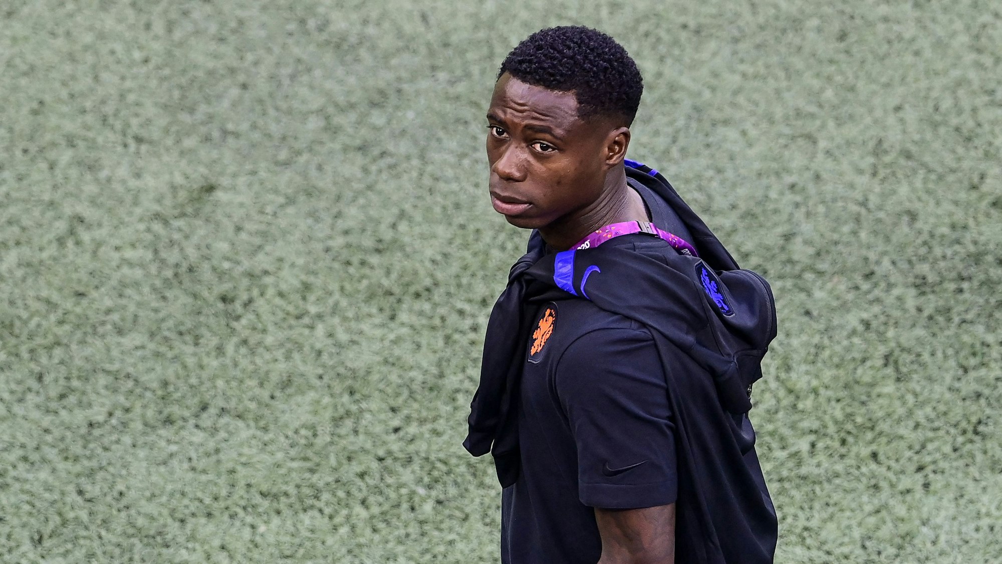 Quincy Promes blickt aus dem Stadion-Innenraum Richtung Tribüne.