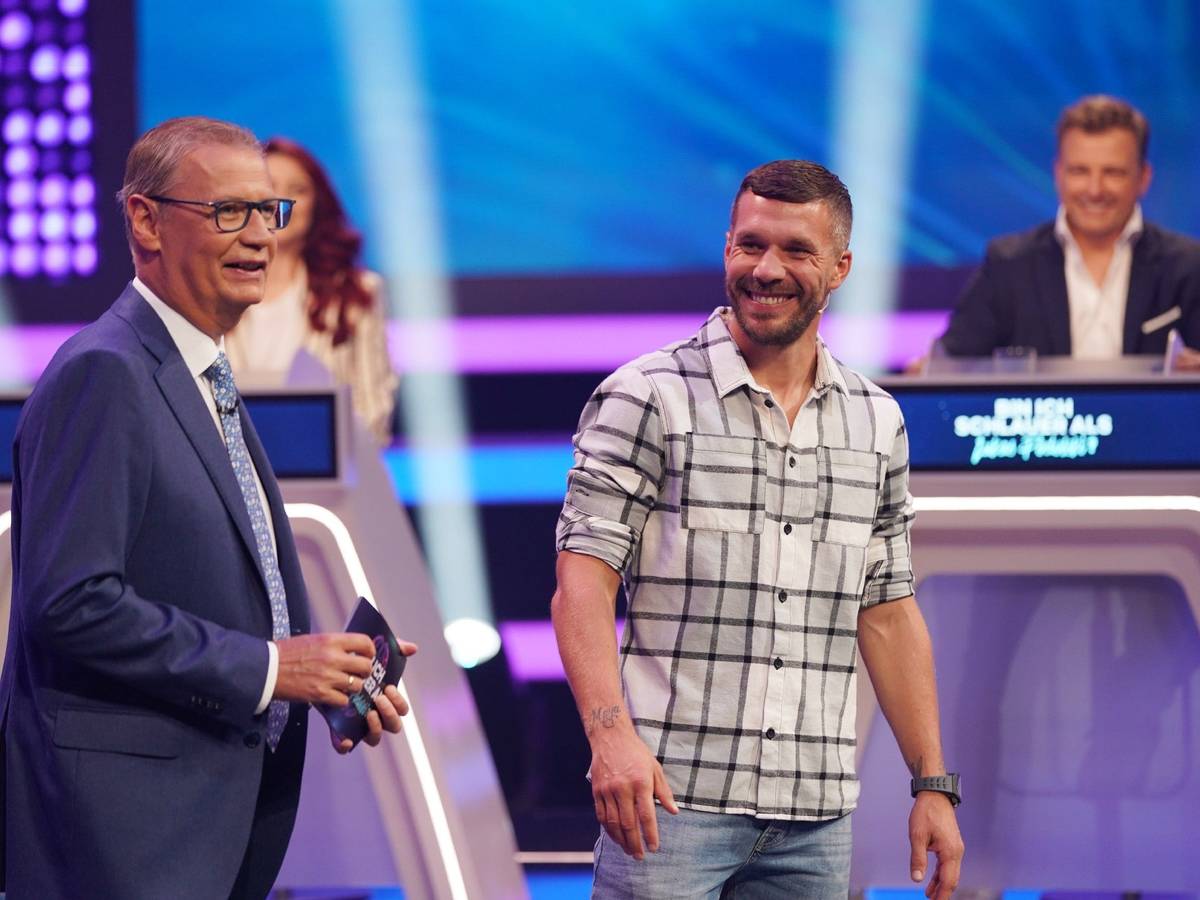 Moderator Günther Jauch und Lukas Podolski stehen in der RTL-Show „Bin ich schlauer als Lukas Podolski?“ nebeneinander.