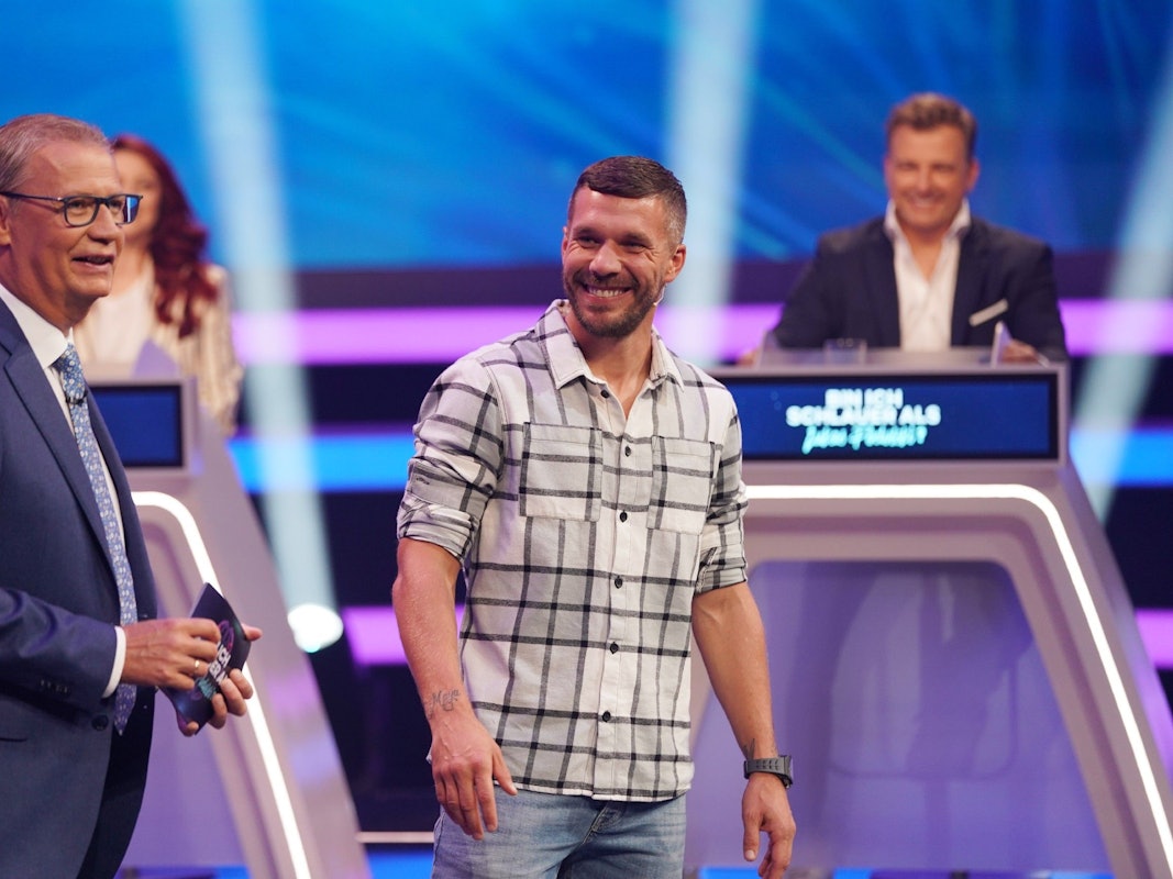 Moderator Günther Jauch und Lukas Podolski stehen in der RTL-Show „Bin ich schlauer als Lukas Podolski?“ nebeneinander.