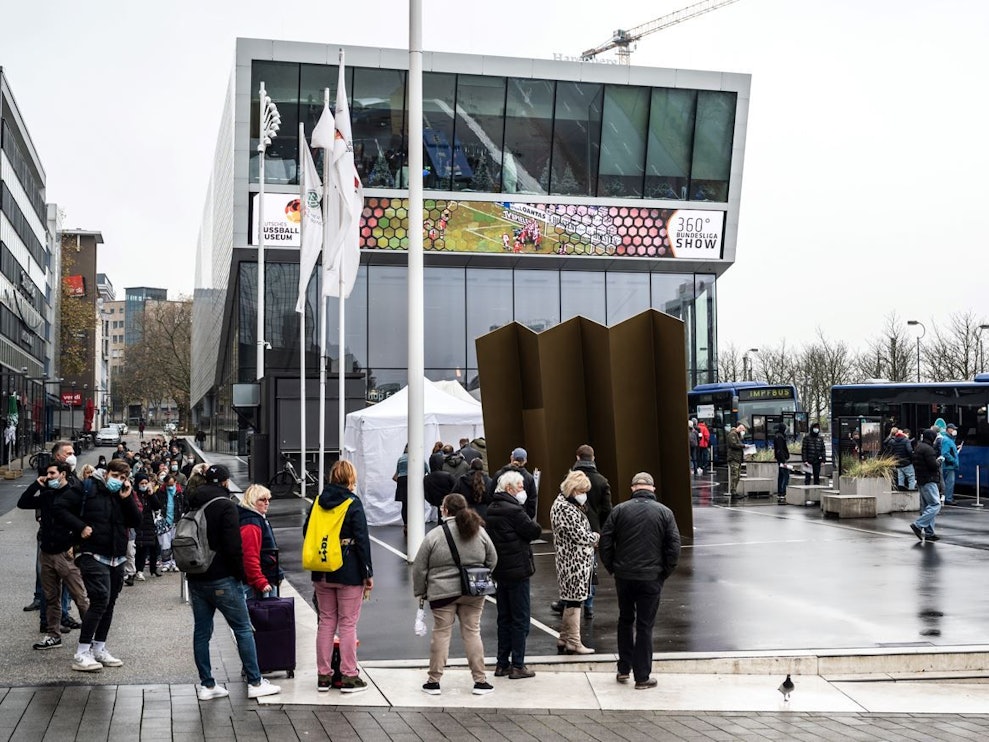 Dortmund: Eine lange Schlange hat sich vor einem mobilen Impfzentrum mit zwei Impfbussen vor dem Deutschen Fußballmuseum gebildet.