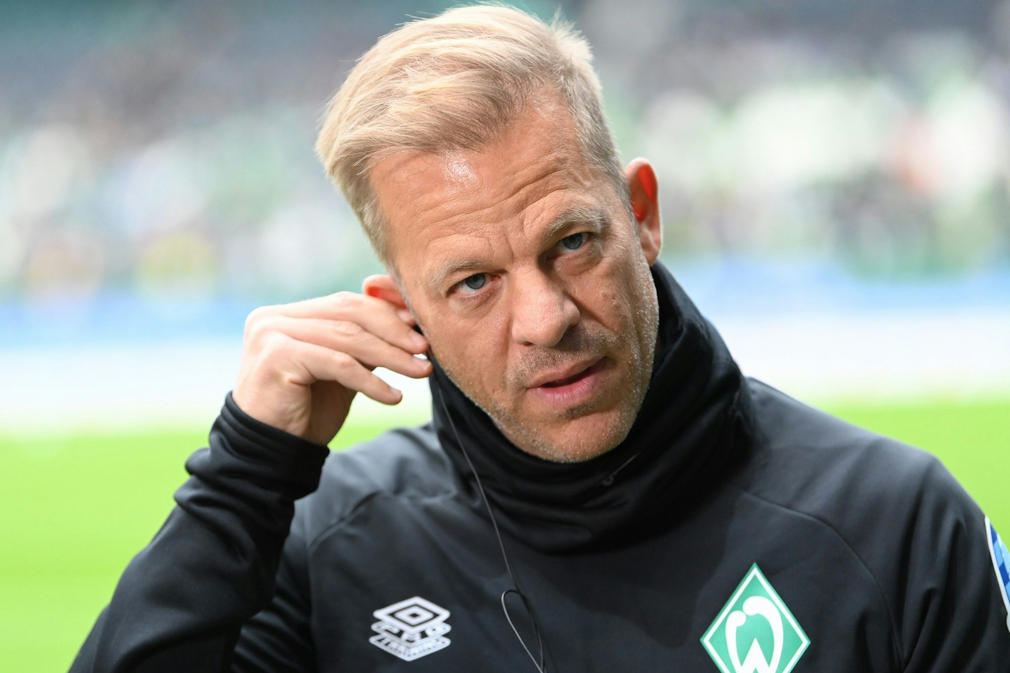 Markus Anfang fasst sich bei einem TV-Auftritt ans Ohr.