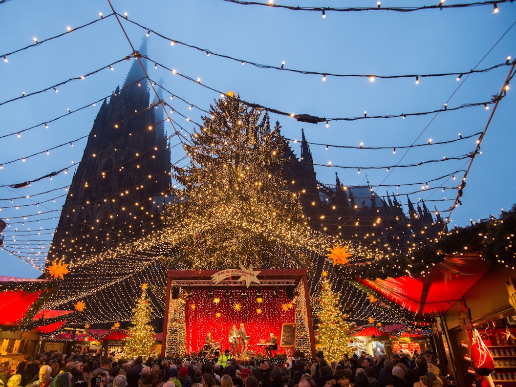 Personen hören sich am 21.12.2017 auf dem Weihnachtsmarkt am Kölner Dom (Nordrhein-Westfalen) eine musikalische Darbietung an. Foto: Rainer Jensen/dpa ++ +++ dpa-Bildfunk +++