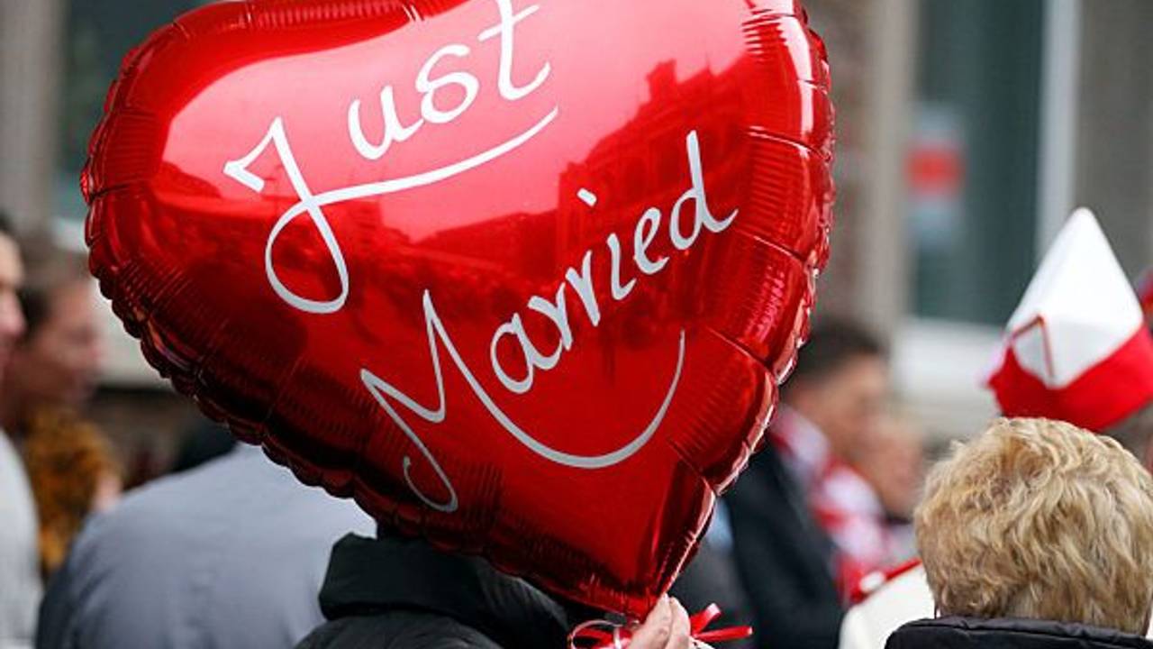 Eine Frau hält am 11.11.2011 in Köln vor dem Rathaus einen Ballon mit der Aufschrift "Just Married" in der Hand.