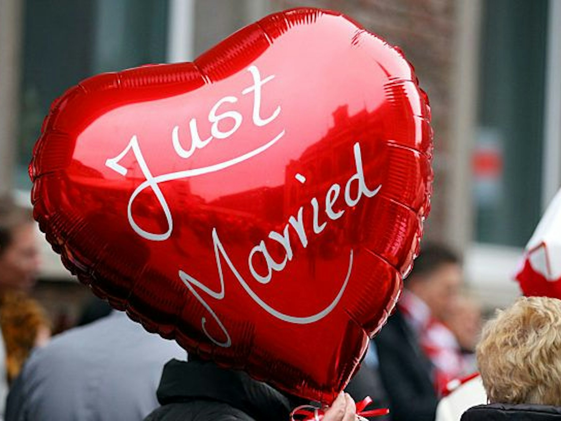 Eine Frau einen Ballon mit der Aufschrift "Just Married" in der Hand.
