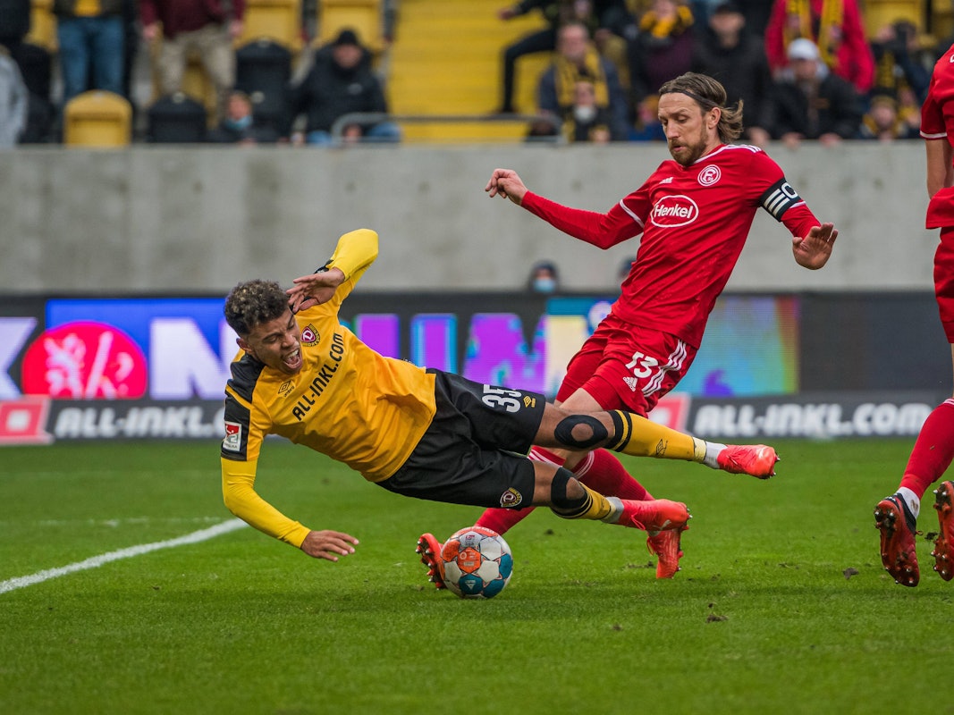 Dresdens Ransford-Yeboah Königsdörffer (l.) kommt im gegnerischen Strafraum zu Fall. Christoph Klarer (r.) hatte gefoult. Adam Bodzek kommt zu spät.