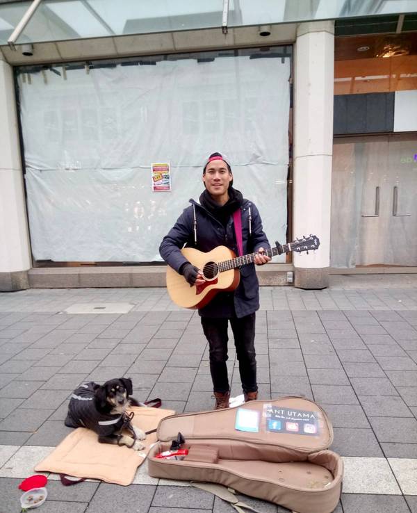 Ant spielt Gitarre. Sein Hund Daisy liegt neben ihm auf dem Boden.