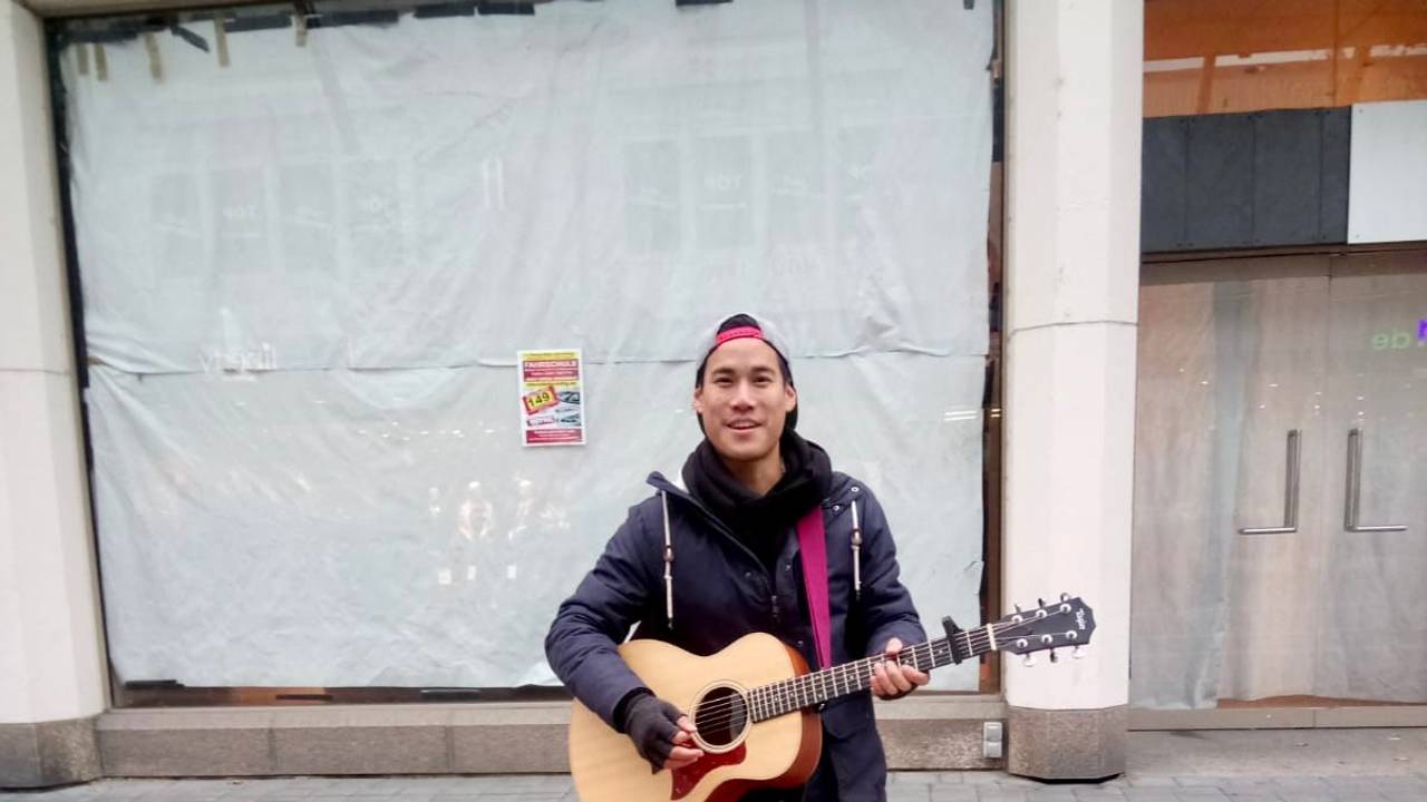 Ant spielt Gitarre. Sein Hund Daisy liegt neben ihm auf dem Boden.