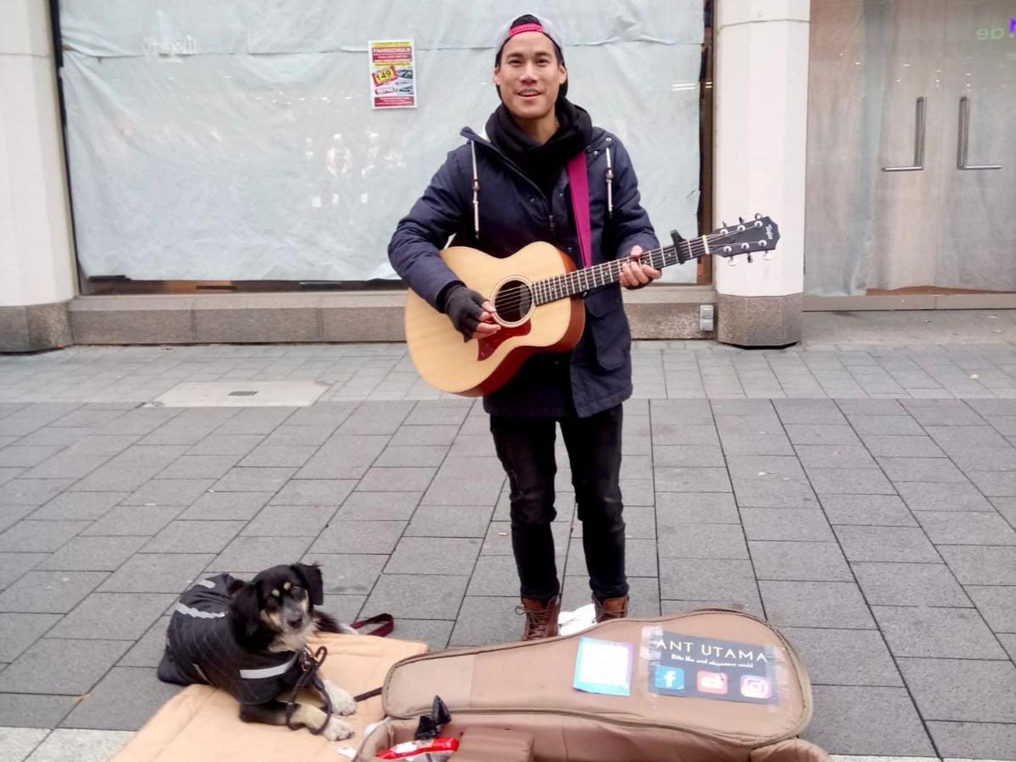 Ant spielt Gitarre. Sein Hund Daisy liegt neben ihm auf dem Boden.