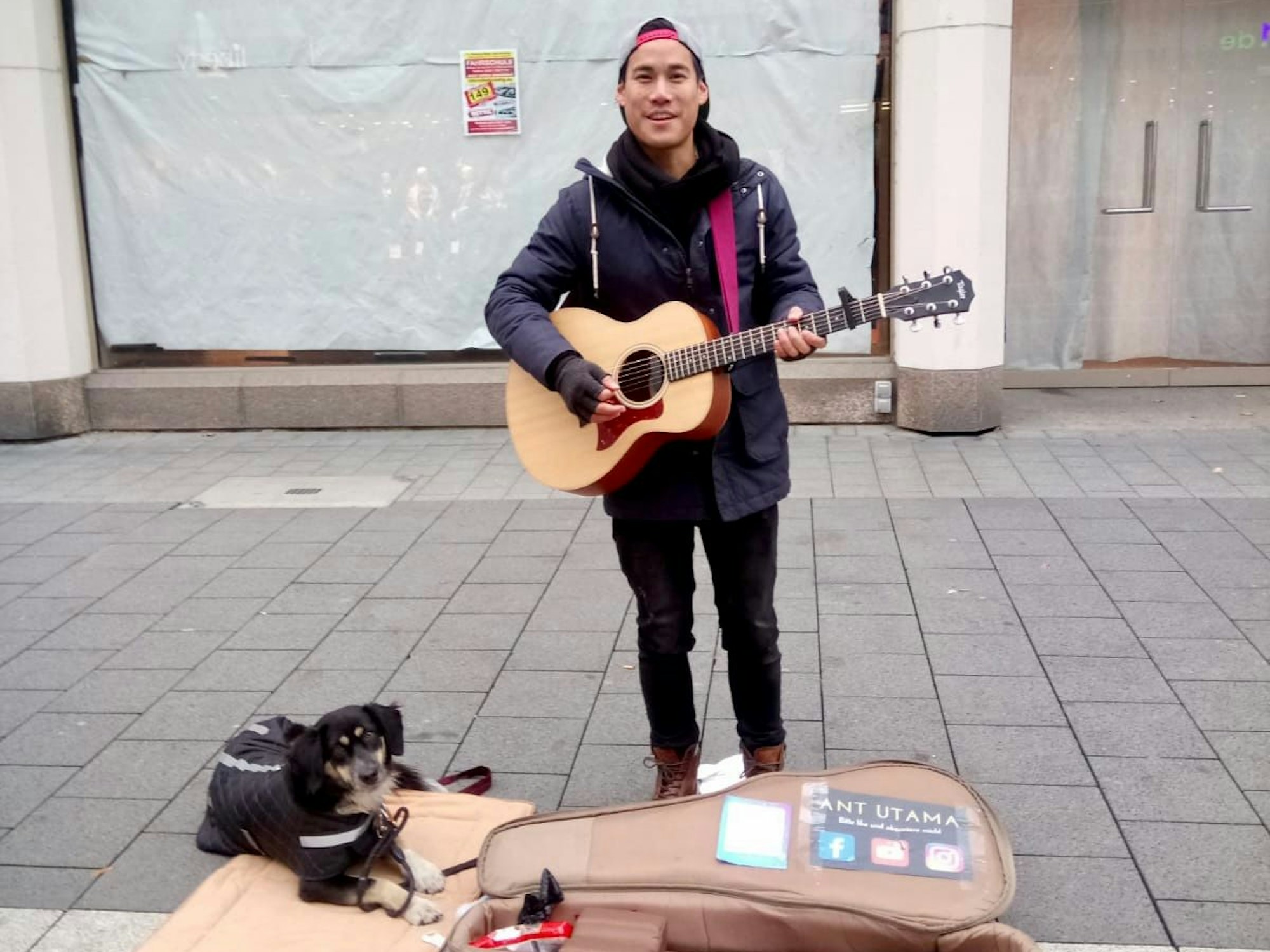 Ant spielt Gitarre. Sein Hund Daisy liegt neben ihm auf dem Boden.