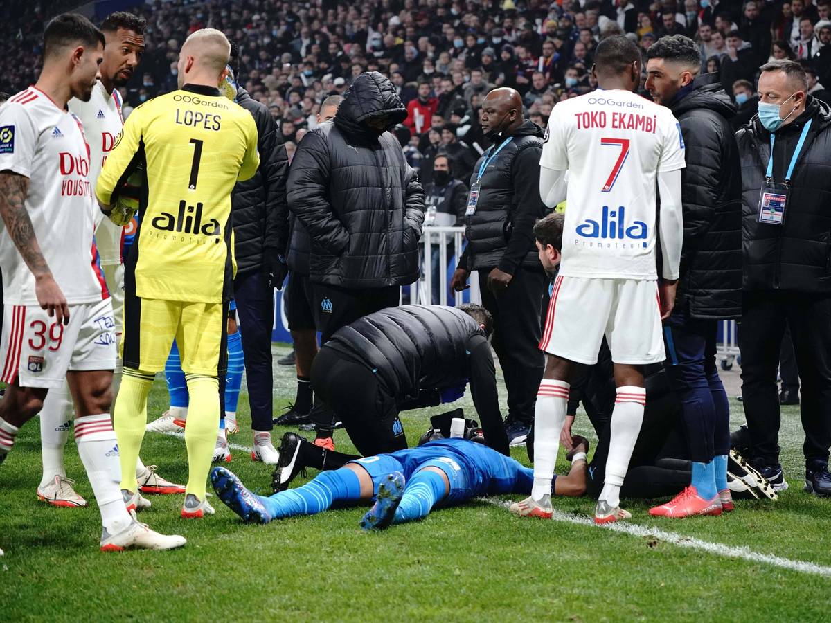 Dimitri Payet am Boden liegend umringt von Betreuern und Kollegen.