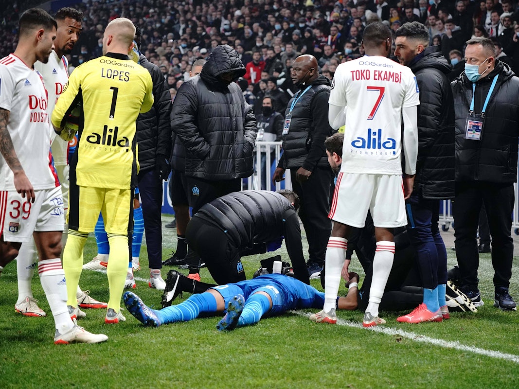 Dimitri Payet am Boden liegend umringt von Betreuern und Kollegen.