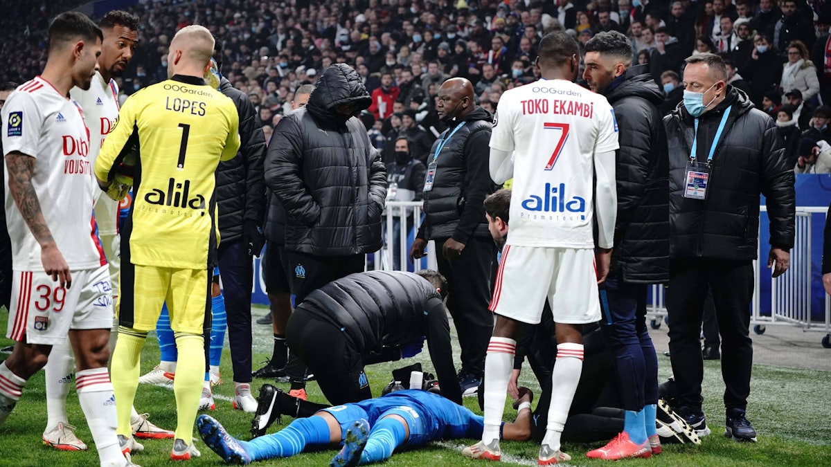 Dimitri Payet am Boden liegend umringt von Betreuern und Kollegen.