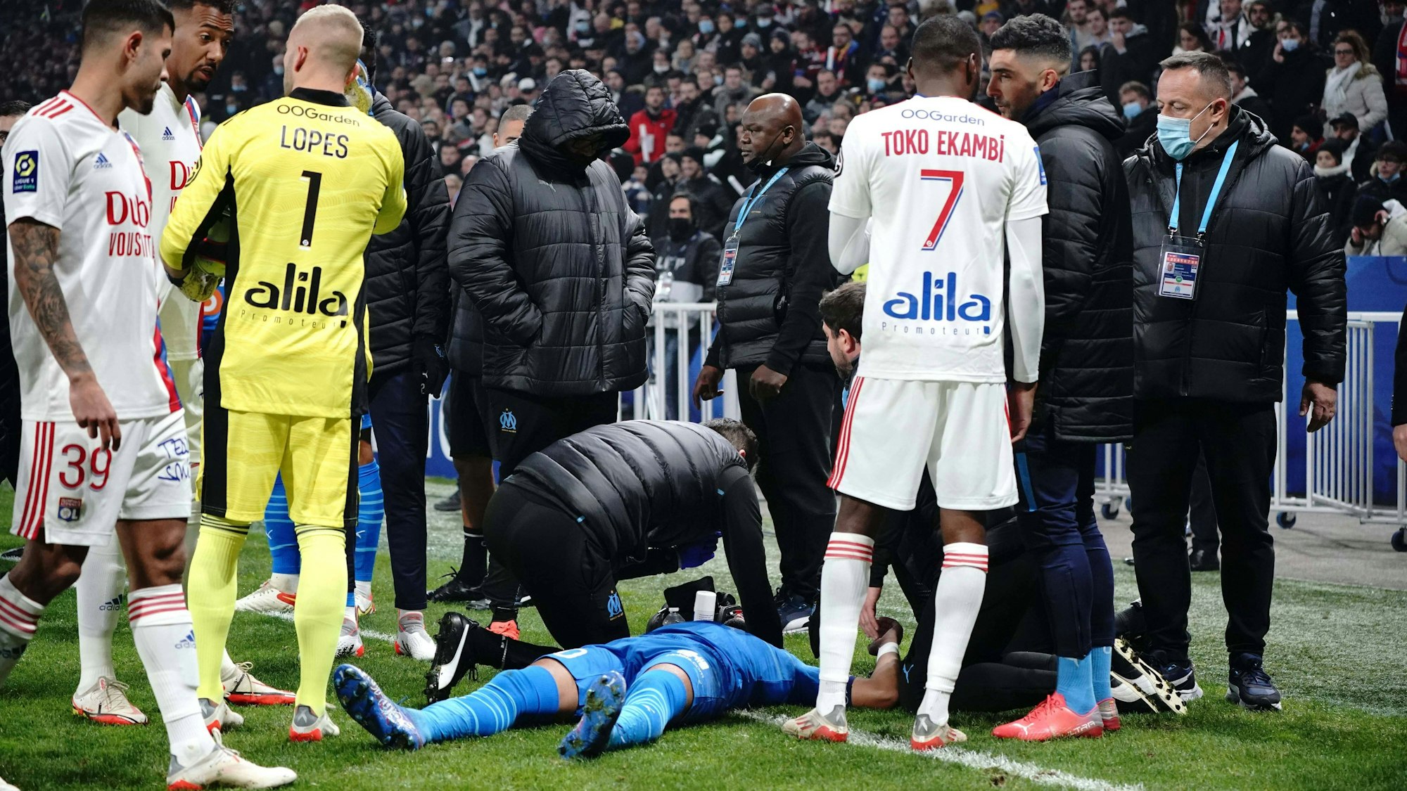 Dimitri Payet am Boden liegend umringt von Betreuern und Kollegen.