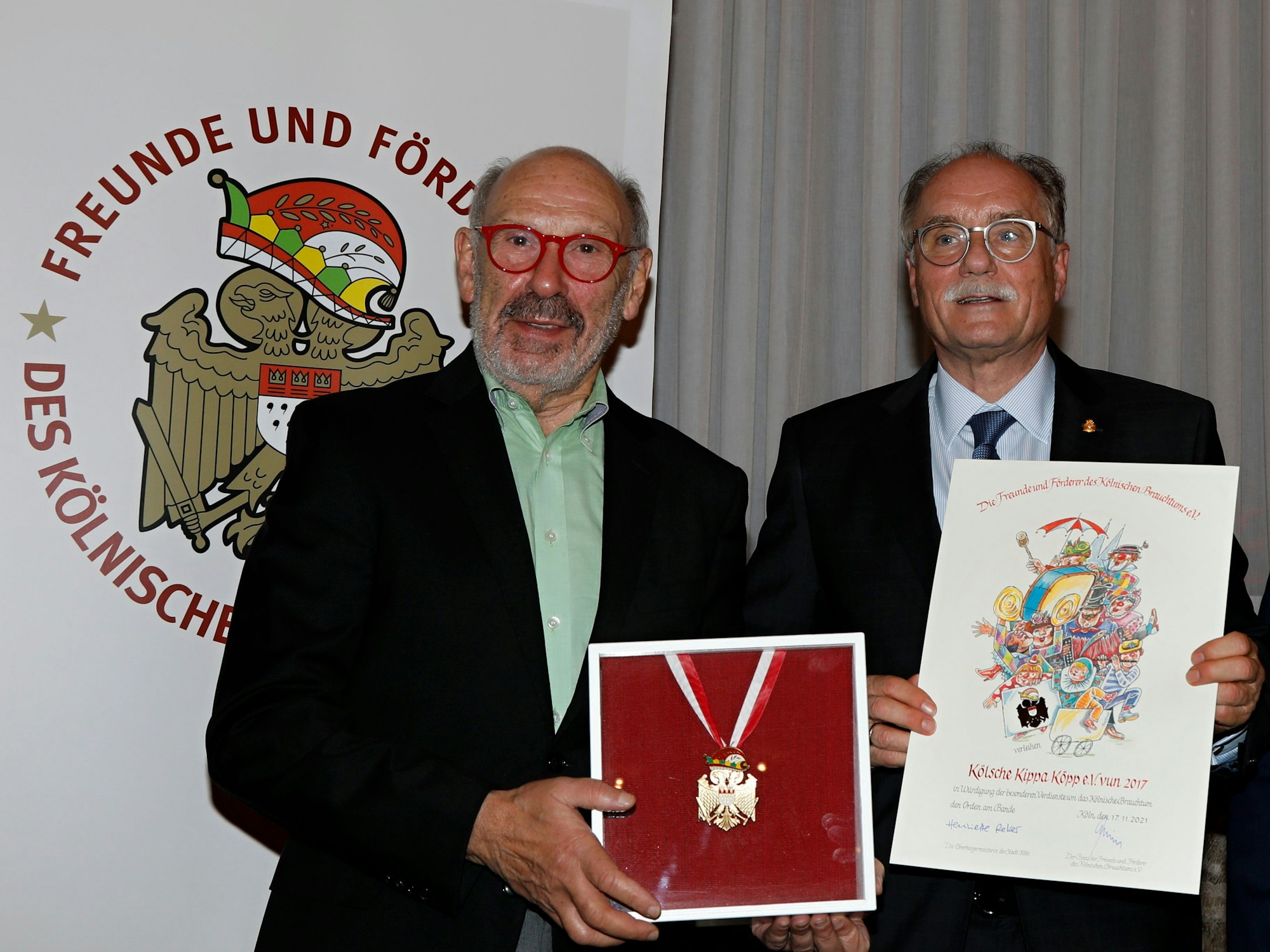 Carlos Levy präsentiert den Orden, neben ihm steht Bernhard Conin.