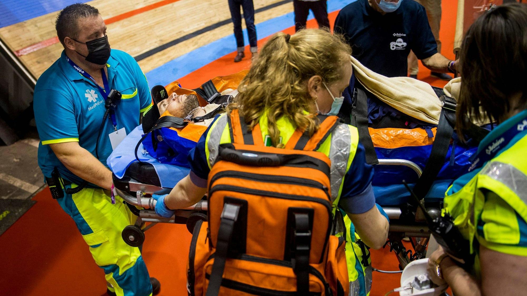 Mediziner bringen Mark Cavendish auf einer Trage aus der Halle.