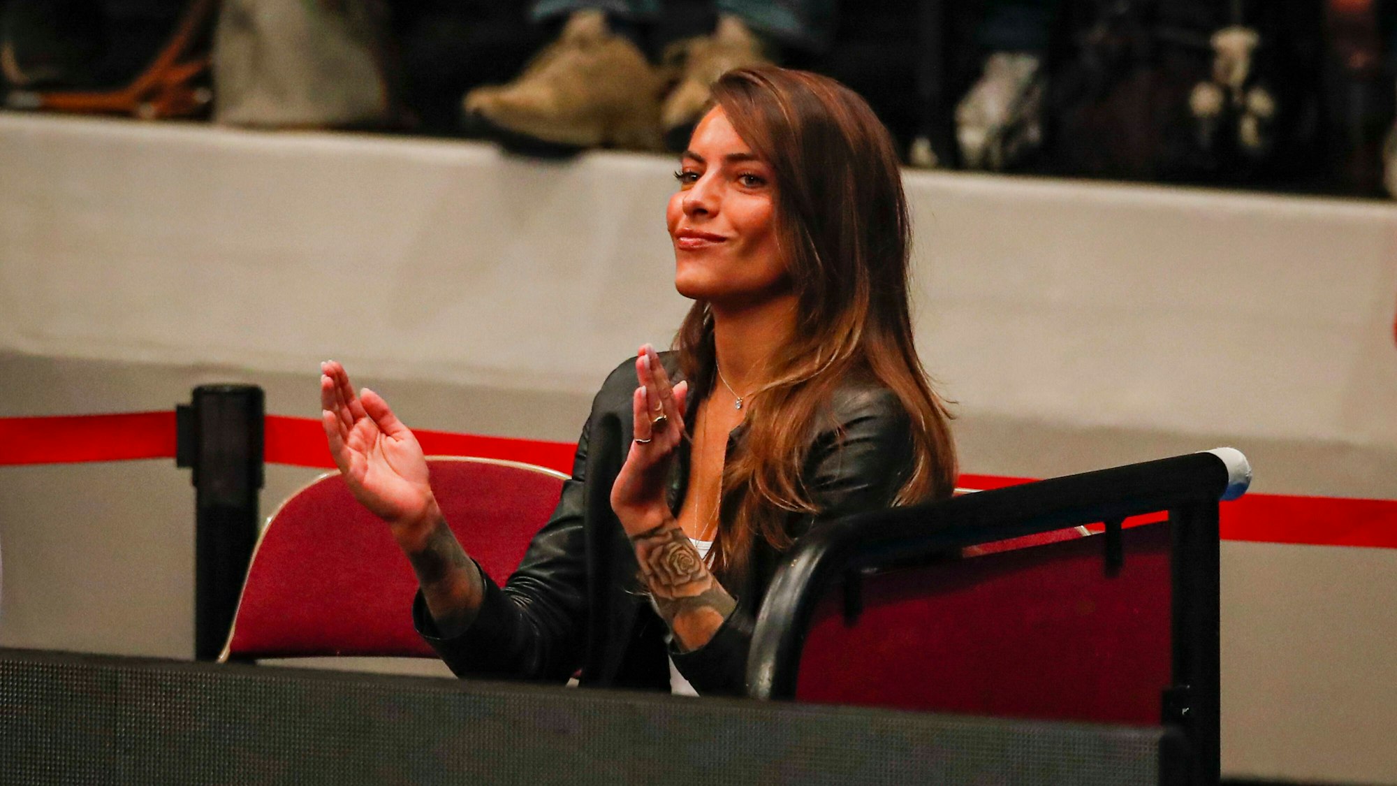 Sophia Thomalla sitzt klatschend auf der Tribüne