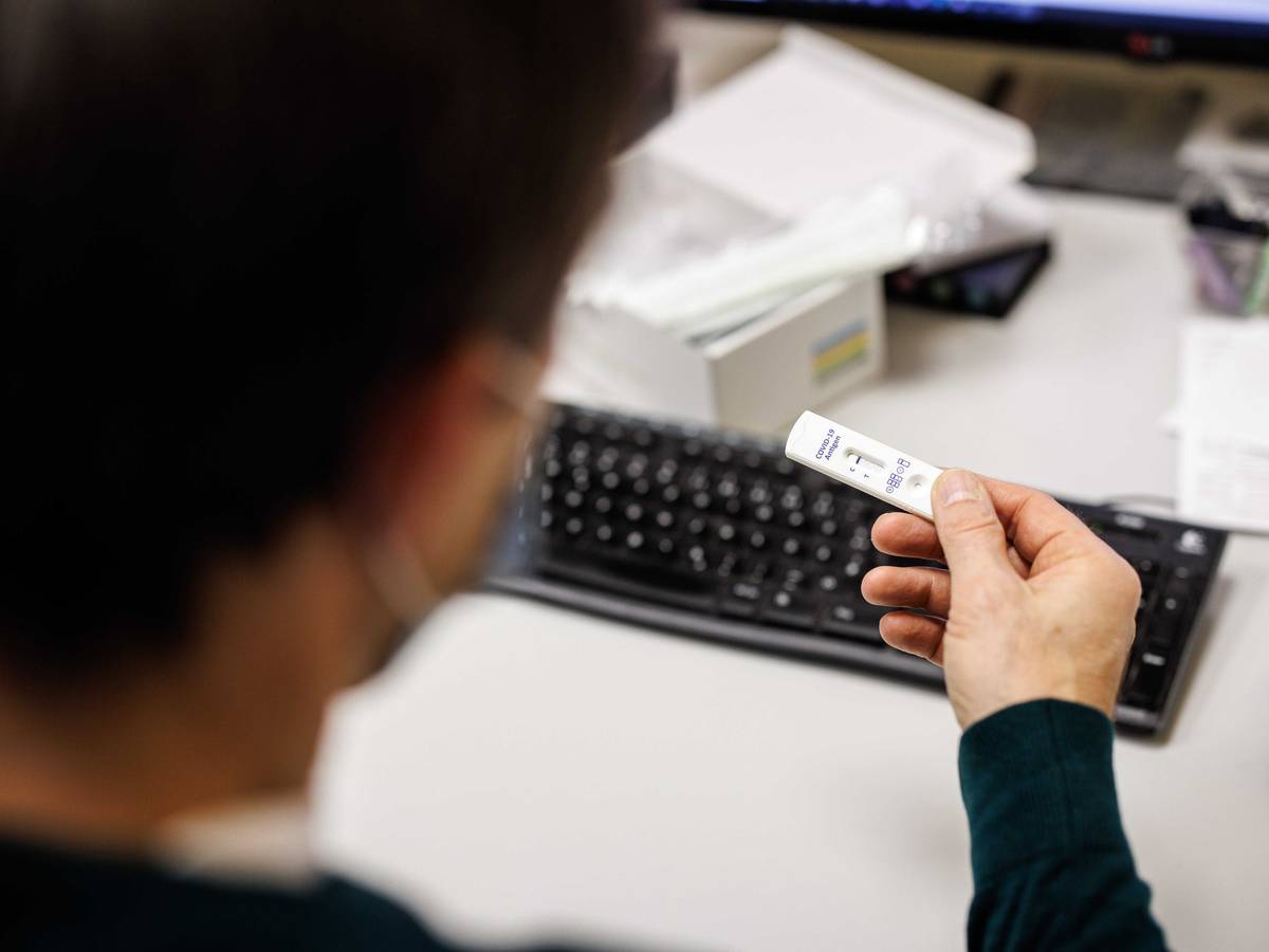 Ein Mitarbeiter blickt in einem Produktionsgebäude der Bäckerei- und Konditoreikette Traublinger auf das Testergebnis für einen Corona-Schnelltest eines anderen Mitarbeiters. +++ dpa-Bildfunk +++