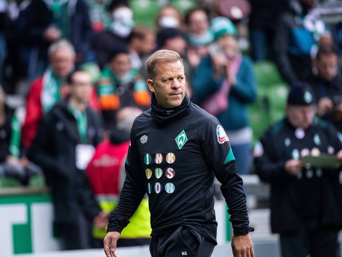 Markus Anfang läuft durch das gefüllte Weserstadion und schaut dabei angespannt.