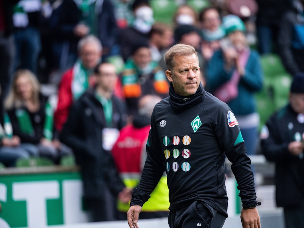 Markus Anfang läuft durch das gefüllte Weserstadion und schaut dabei angespannt.