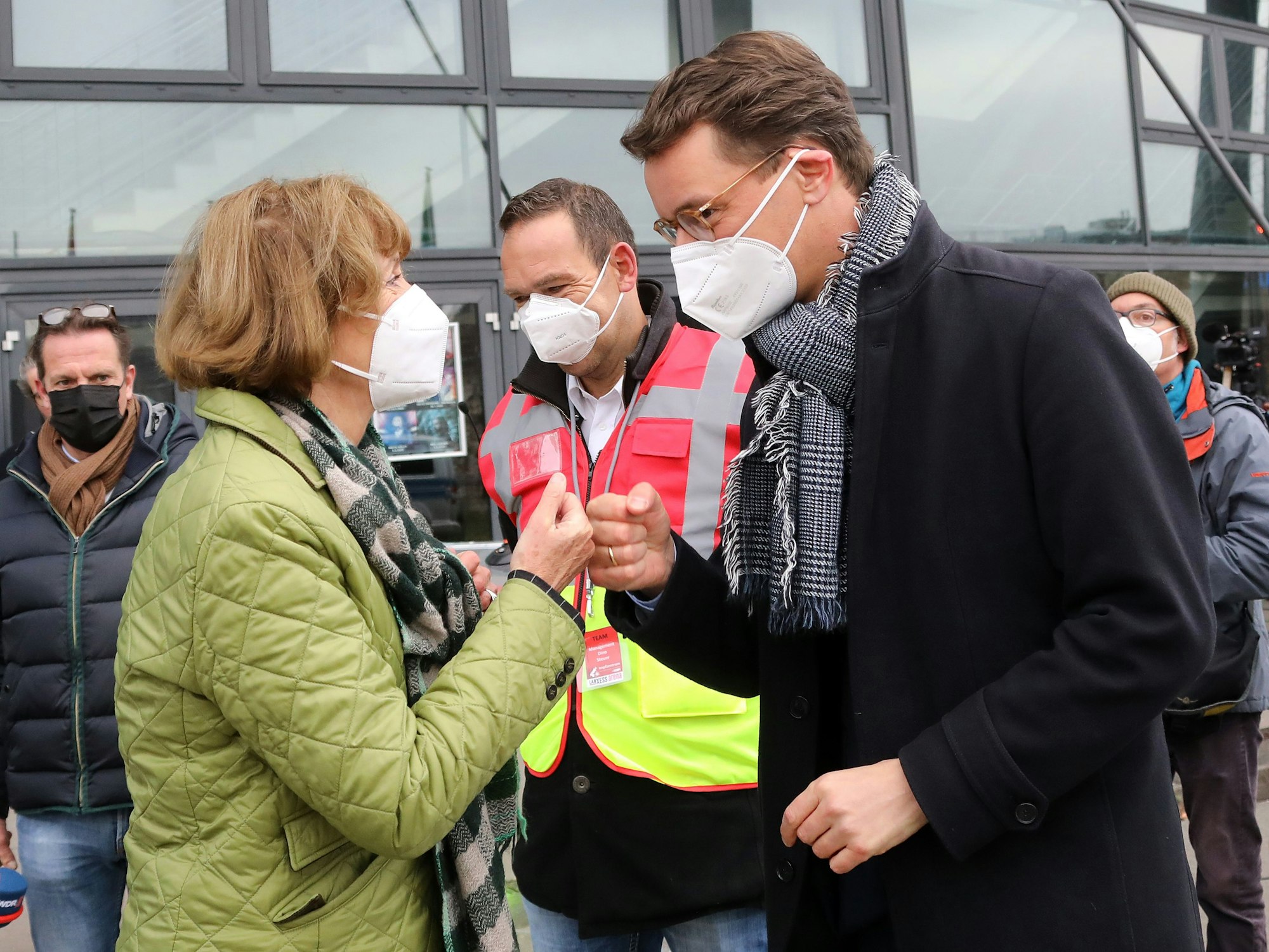 Oberbürgermeisterin Henriette Reker und Ministerpräsident Hendrik Wüst begrüßen sich vor dem Eingang der Lanxess Arena.