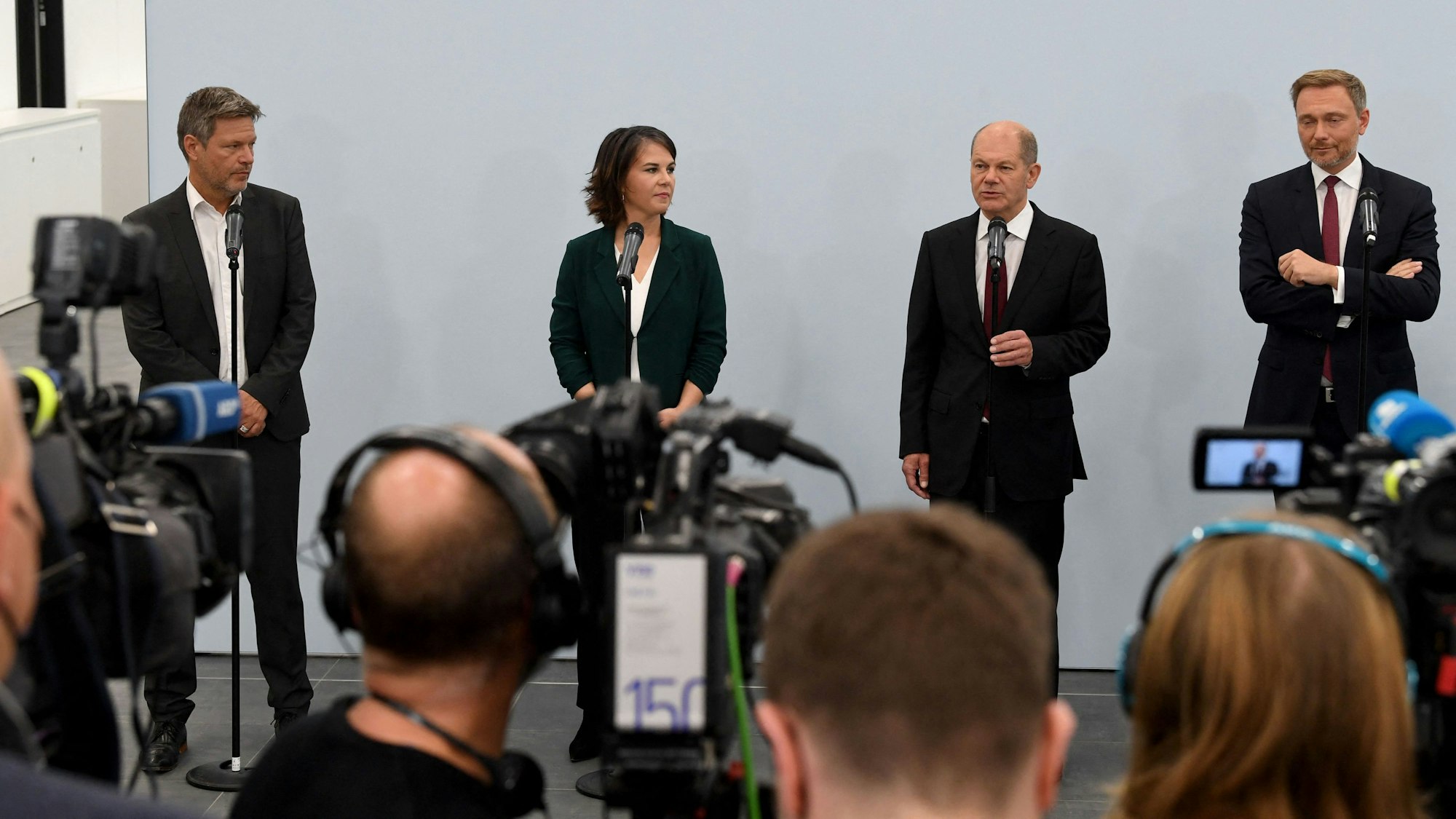 Robert Habeck, Annalena Baerbock, Olaf Scholz und Christian Lindner stehen auf einer Bühne nebeneinander.