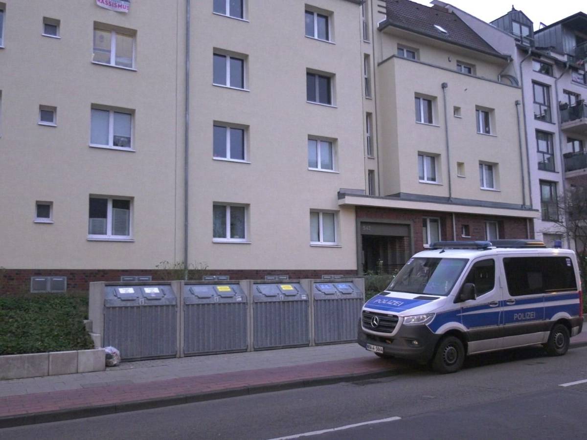 Ein Polizeifahrzeug steht vor einem Mehrfamilienhaus in Köln.