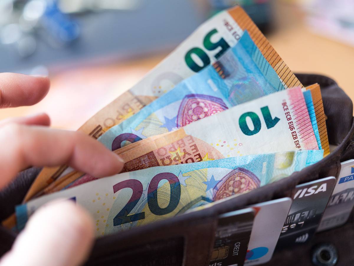 Eine Frau hält eine Geldbörse mit zahlreichen Banknoten und Bankkarten in der Hand. Zu: Wie Sie im Jahr richtig viel Geld sparen können.