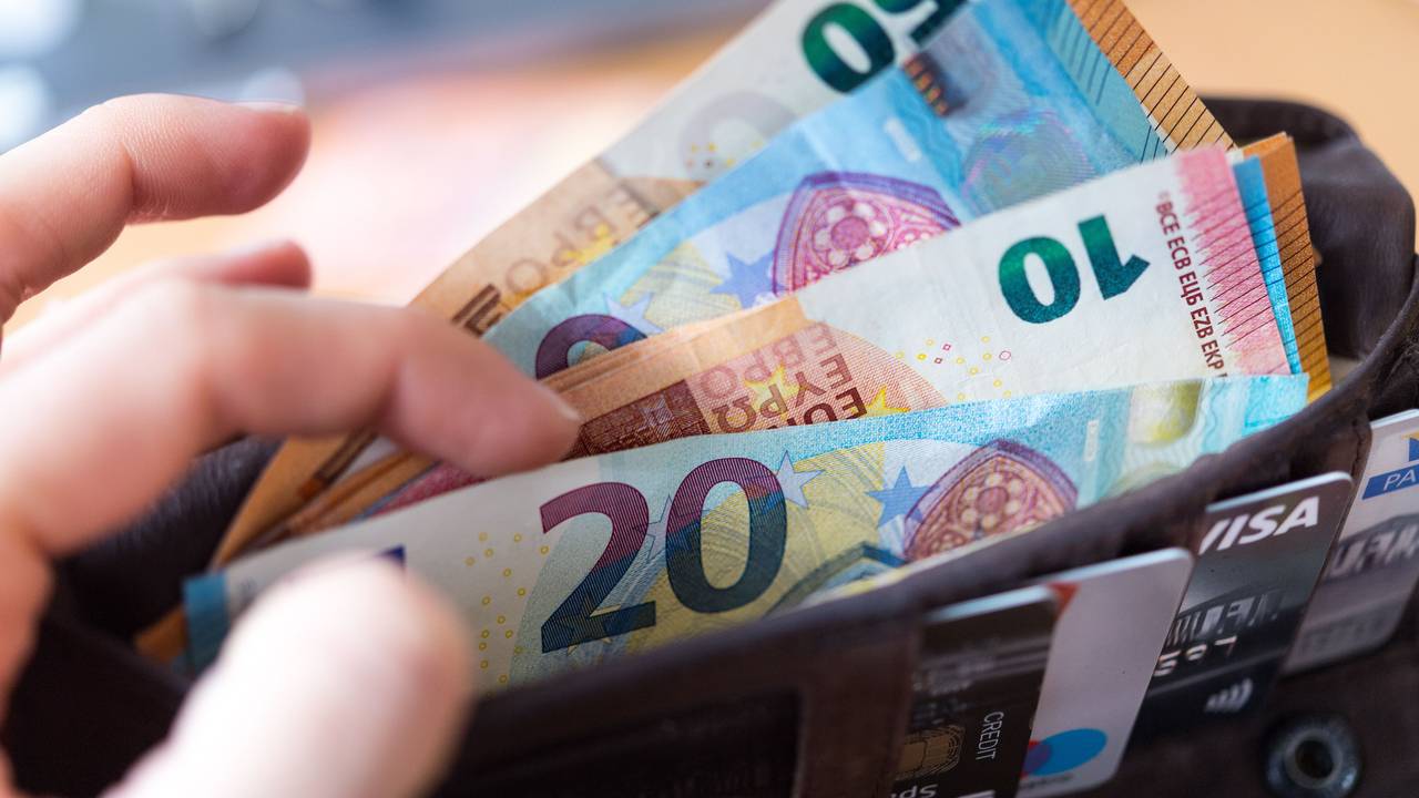 Eine Frau hält eine Geldbörse mit zahlreichen Banknoten und Bankkarten in der Hand. Zu: Wie Sie im Jahr richtig viel Geld sparen können.