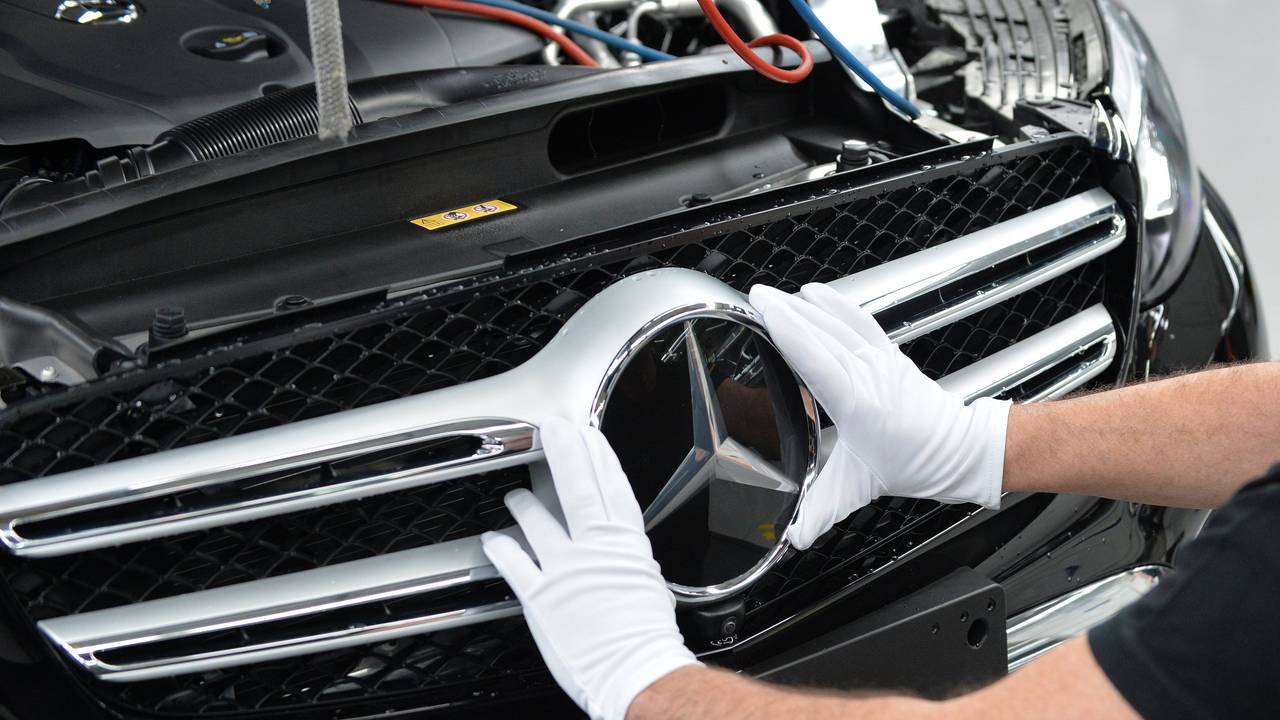 Mercedes-Benz ruft acht Modelle zurück. Dieses undatierte Symbolfoto zeigt einen Arbeiter, der einen Mercedes-Stern am Fahrzeug montiert.