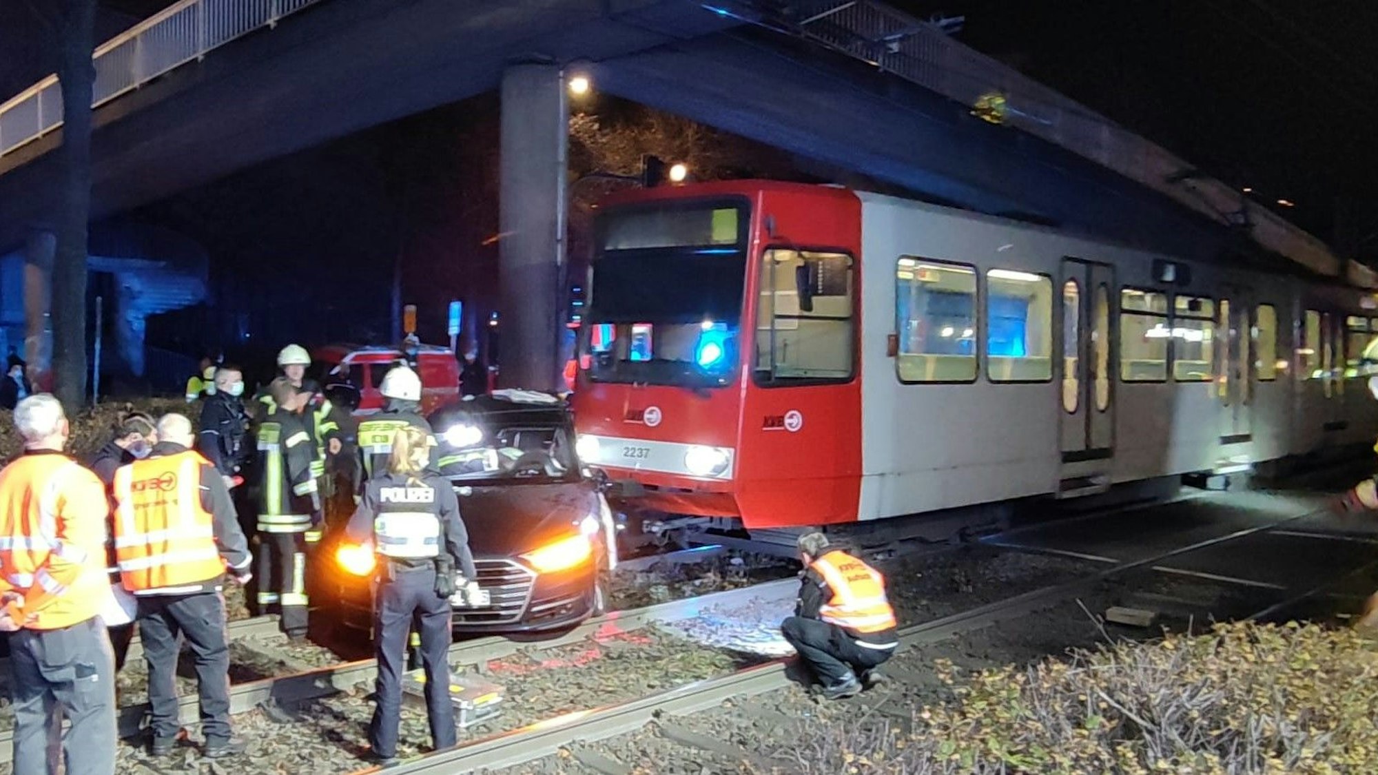 Ein Auto und eine Straßenbahn sind kollidiert. Das Auto steht auf den Gleisen. Kräfte von Polizei und Feuerwehr sind im Einsatz.