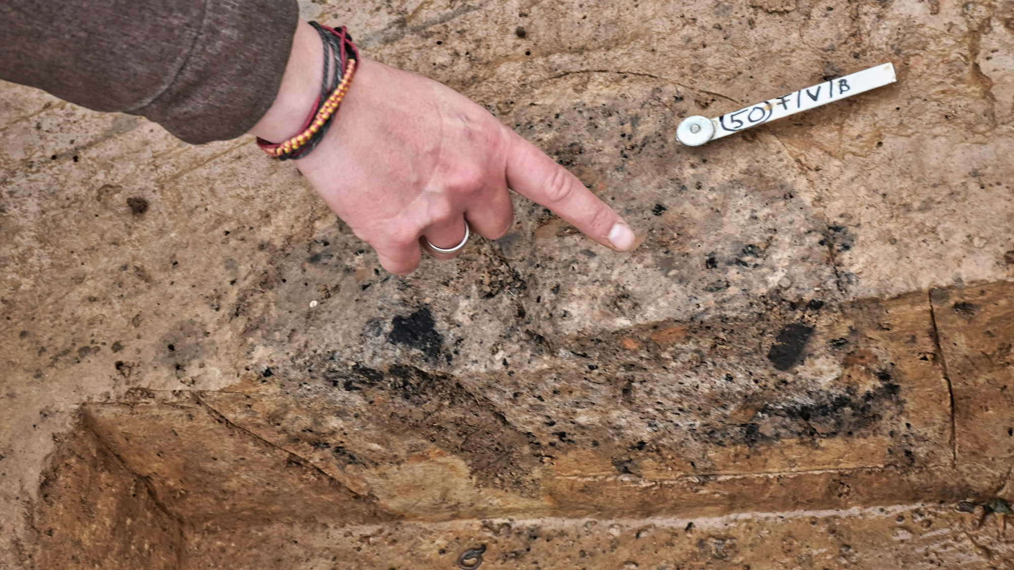 Das Foto (aufgenommen am 19. November 2021) zeigt die schwarze Verfärbung des Bodens in der archäologischen Ausgrabung an der A44 bei Werl.