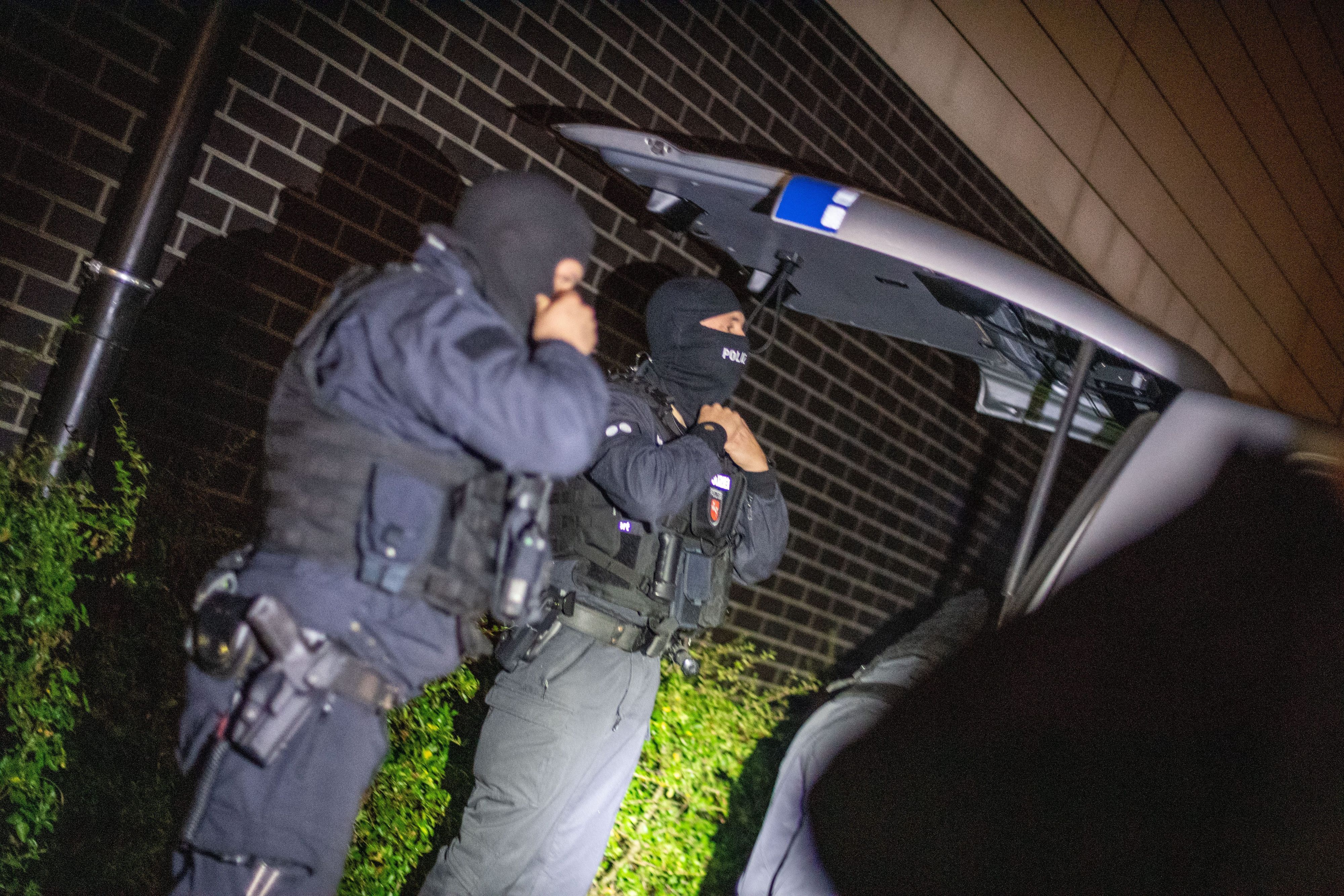 Einsatzkräfte der Polizei bereiten sich vor dem Zugriff auf ein Objekt an einem Sammelpunkt vor.