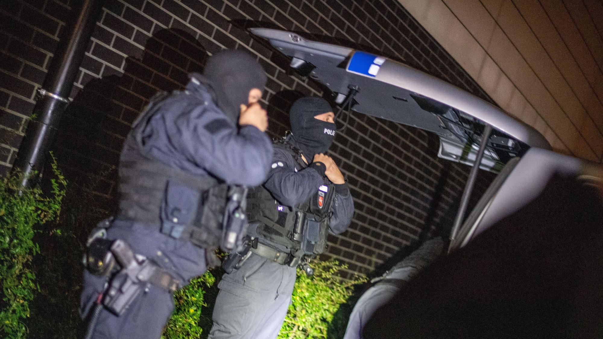 Einsatzkräfte der Polizei bereiten sich vor dem Zugriff auf ein Objekt an einem Sammelpunkt vor.