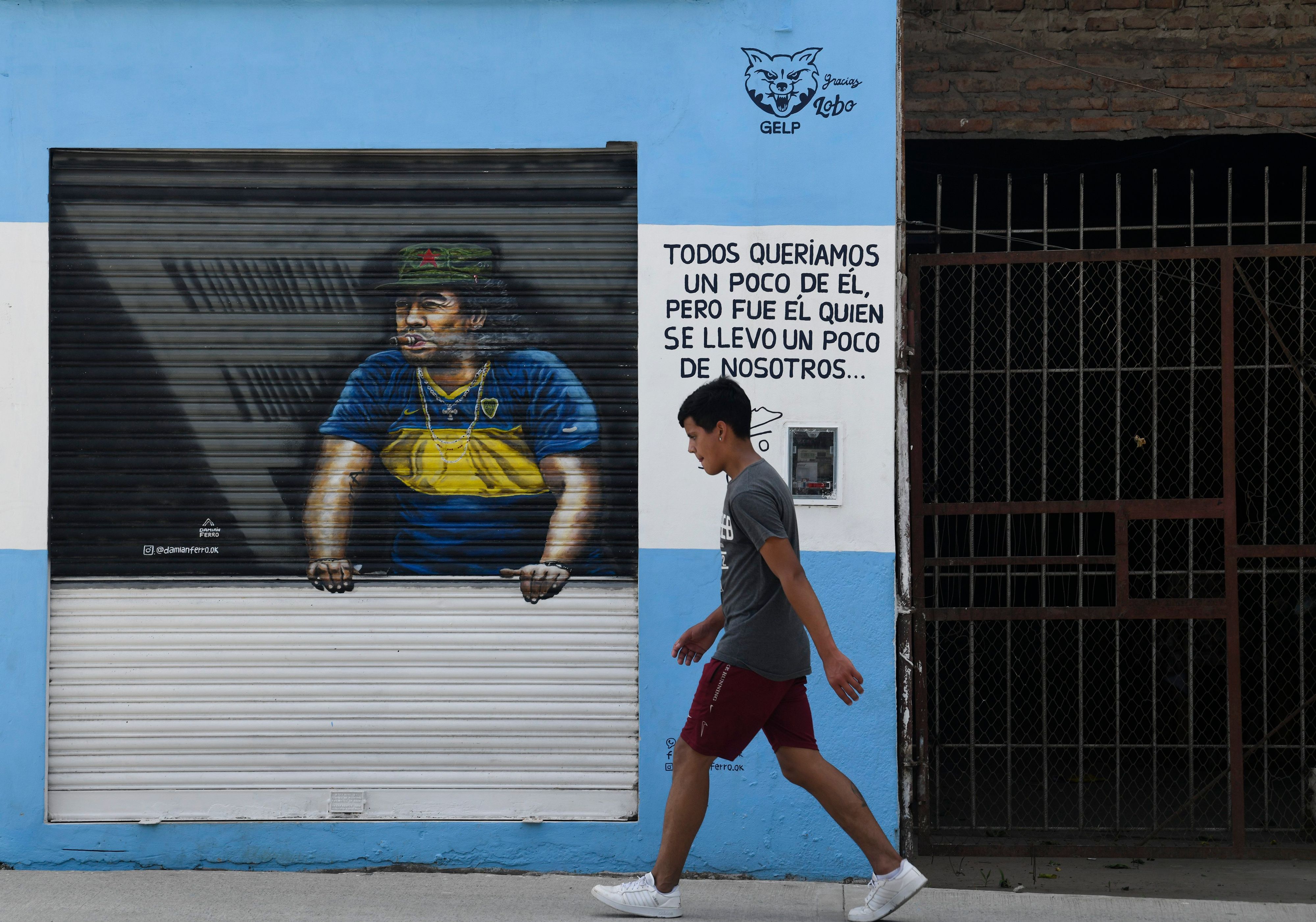 Ein Fußgänger schreitet an einem Gemälde von Diego Maradona vorbei.