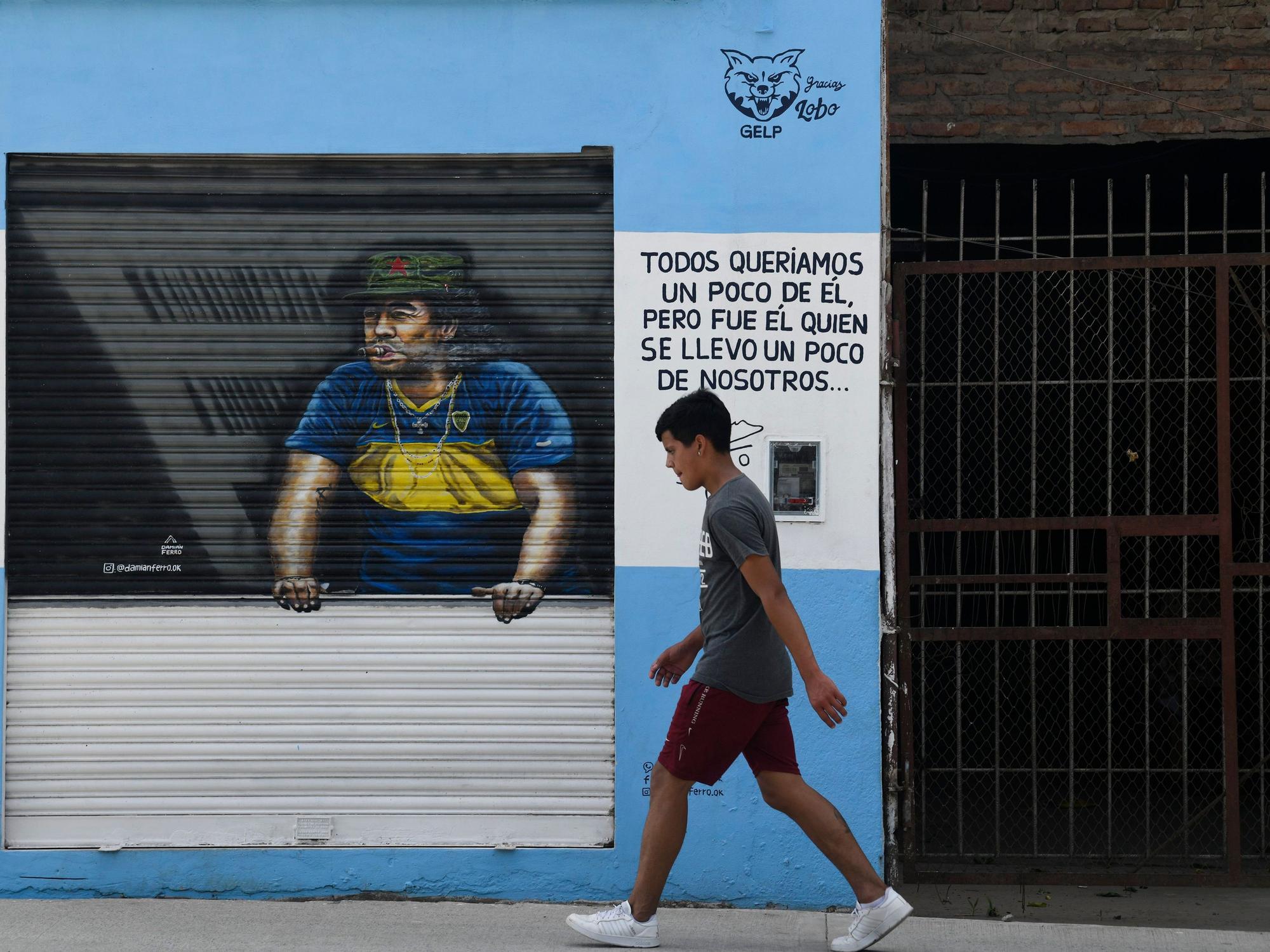 Ein Fußgänger schreitet an einem Gemälde von Diego Maradona vorbei.