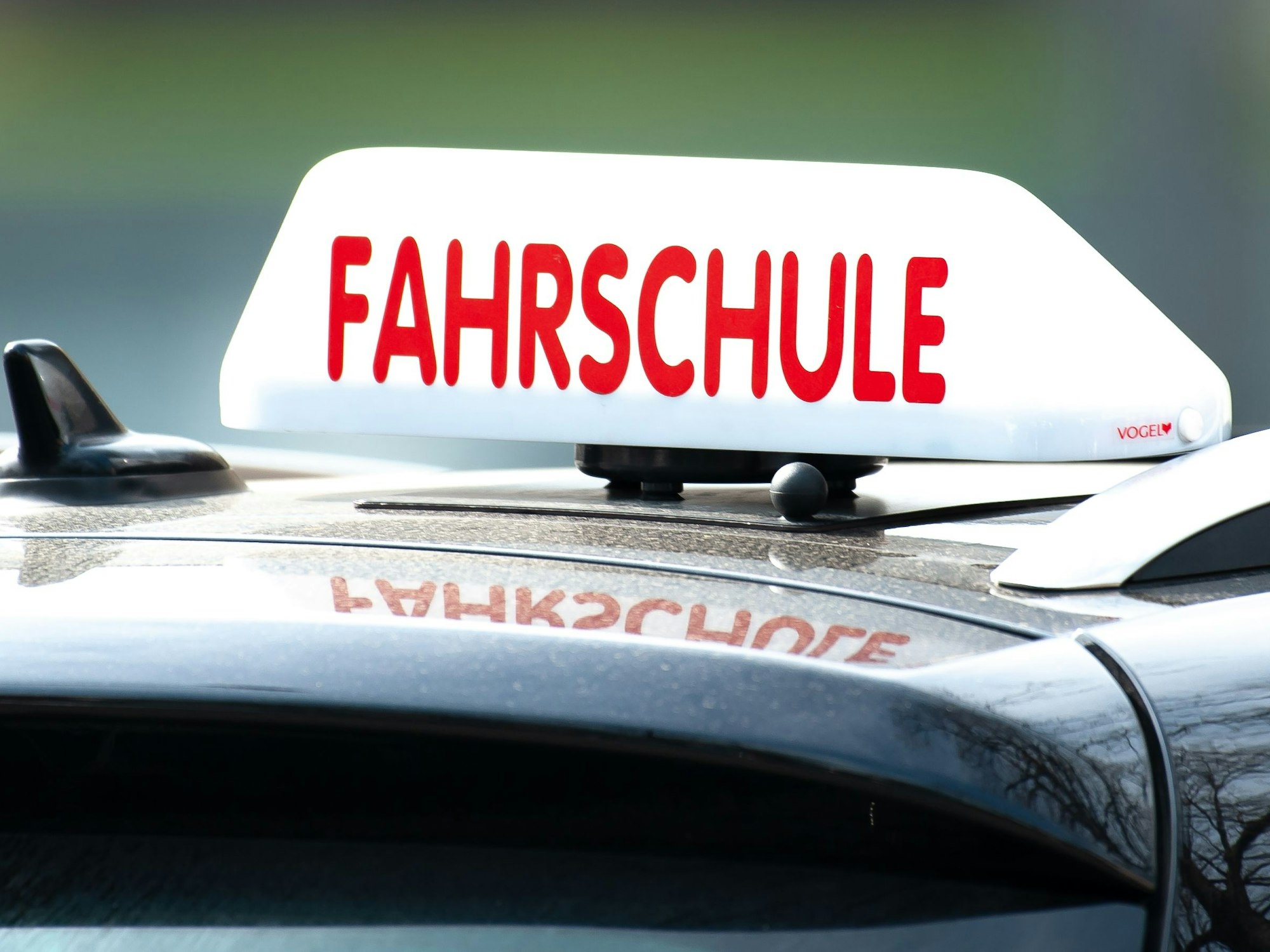 Ein Dachschild mit der Aufschrift «Fahrschule» ist auf einem Fahrschulauto befestigt.